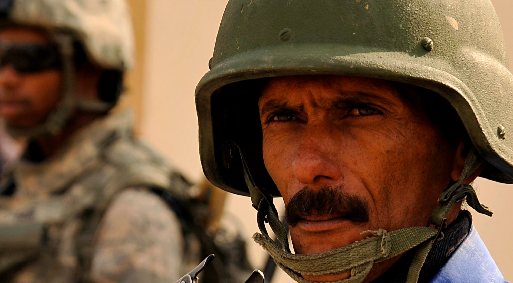 An Iraqi Police officer waits while Airmen from the 732nd Expeditionary Security Forces Squadron Det 2, deployed to Baghdad, Iraq, form up in order to conduct a foot patrol, Nov. 19, 2009. (U.S. Air Force photo/Staff Sgt. Angelita Lawrence)