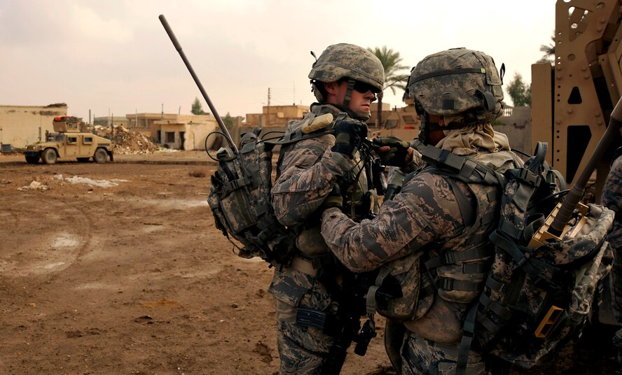Richard Acosta and Joseph Hovis help one another with their gear prior to conducting a foot patrol through Baghdad with Iraqi Police. Both are senior airmen assigned to the 732nd Expeditionary Security Forces Squadron Det. 2, deployed to Baghdad. (U.S. Air Force photo/Staff Sgt. Angelita Lawrence)