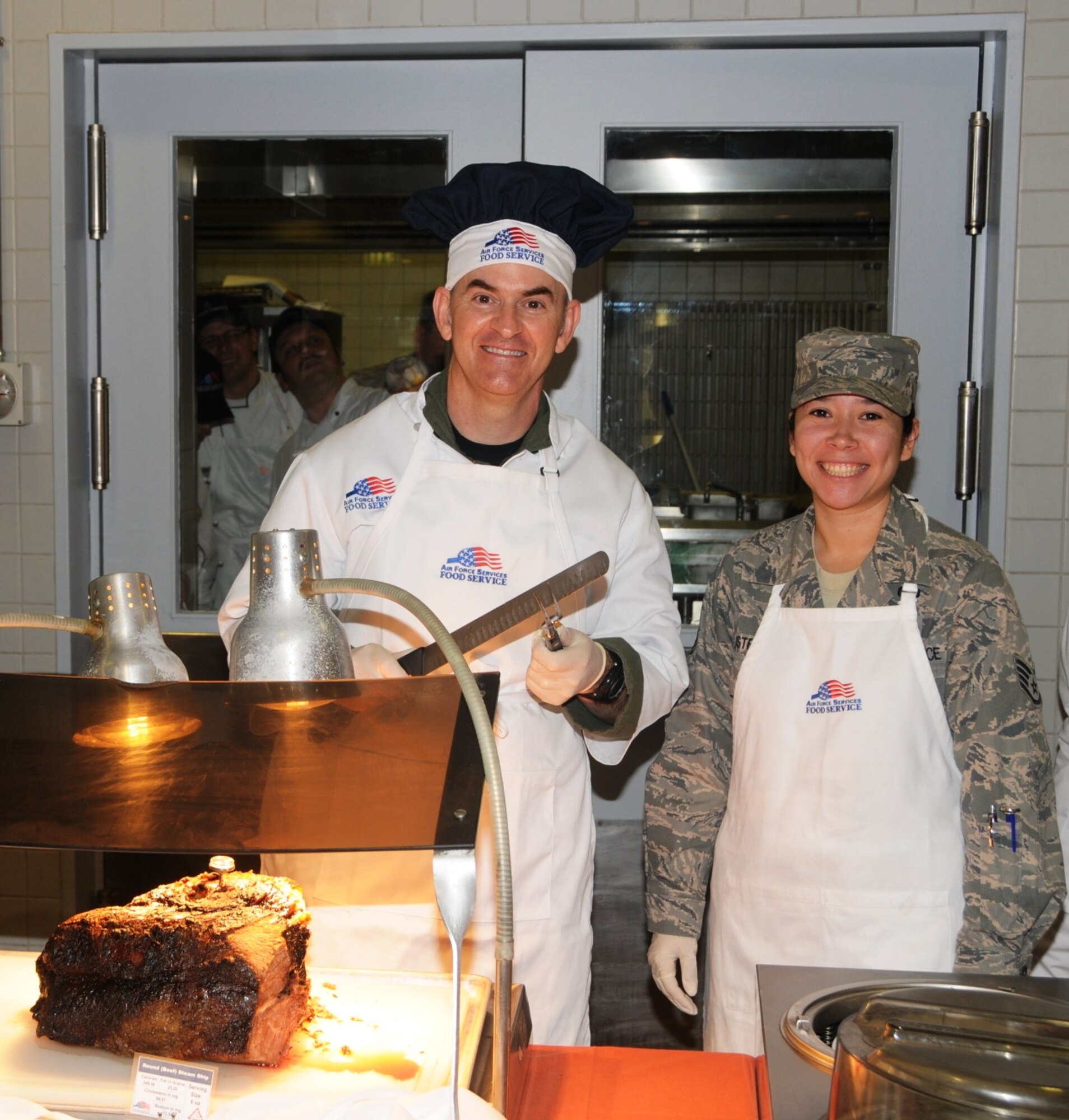 RAMSTEIN AIR BASE, Germany -- 17th Air Force Vice Commander Brig. Gen. Michael Callan (left) joins Shift Leader Staff Sgt. Samantha Bustraan, 86th Services Squadron, at the Ramstein Dining Facility Thanksgiving Day (Nov. 26) to serve and celebrate the holiday with troops and their families. (USAF photo by Master Sgt. Jim Fisher)