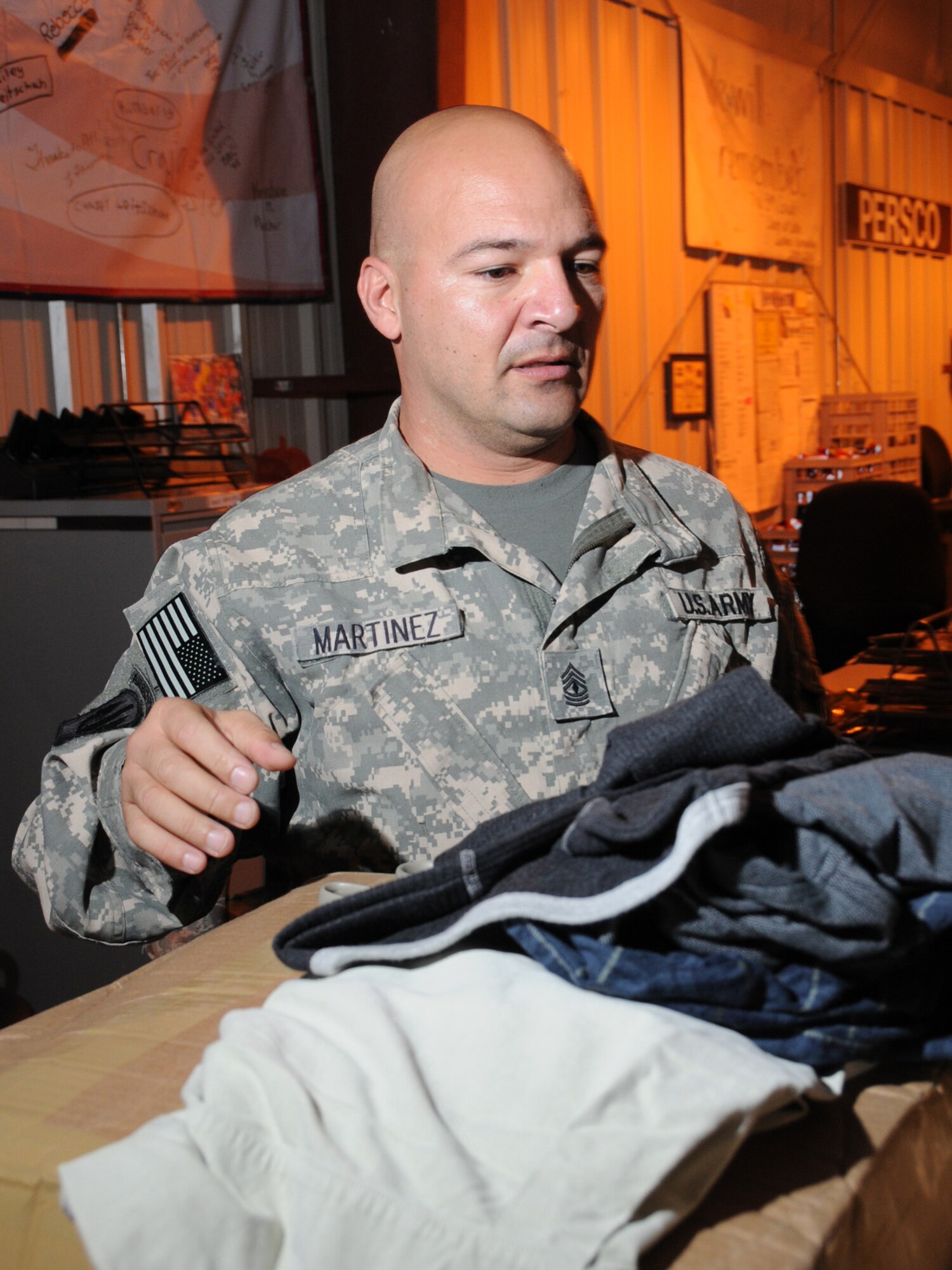First Sgt. Julio Martinez, 379th Expeditionary Operations Group, Army Priority Air Transport, Europe Flight Detachment, donates clothes at the Personnel Support for Contingency Operations center, Nov. 25, 2009, for use by deployed servicemembers traveling home on emergency leave. The clothes were donated by various organizations on Ramstein Air Base, Germany, 1st Sgt. Martinez' home station. (U.S. Air Force Photo/Tech. Sgt. Jason W. Edwards)