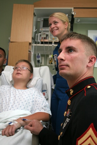 Recruiting Station Des Moines Recruiter Sgt. Karl Krebsbach visits with Kennedy Feller, 12, while escorting Navy Blue Angel Flight Surgeon Lt. Johannah Valentine at the Children’s Hospital & Medical Center Aug. 28 in Omaha, Neb. Krebsbach feels a personal connection with the hospital because his three-year-old son receives treatment there for a heart condition.