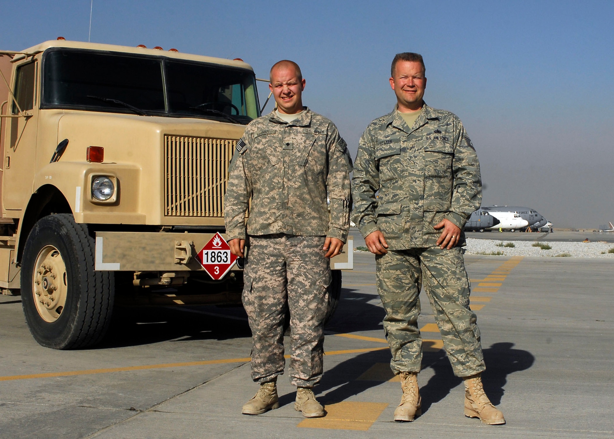 BAGRAM AIRFIELD, Afghanistan -- Army Spc. Kevin Leaman (left), a vehicle maintainer with the Fourth Infantry Division, poses for a photo with his dad, Tech. Sgt. Thomas Leaman (right), the fuels mobility support equipment shop non-commissioned officer in charge of the 455th Expeditionary Logistics Readiness Squadron.  Sergeant Leaman is an Air Force Reservist deployed from the 302nd Airlift Wing at Peterson Air Force Base, Colo.  Specialist Leaman is deployed from Fort Carson, Colo.  (U.S. Air Force photo/Senior Airman Felicia Juenke)