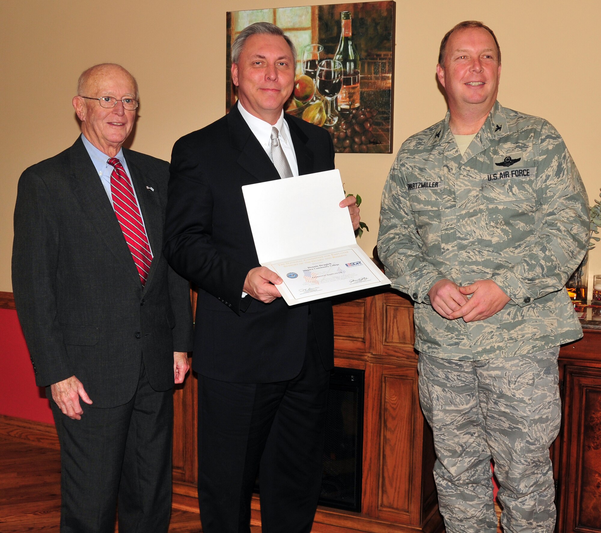 NIAGARA FALLS AIR RESERVE STATION, N.Y. -- Local employers received the Patriot Award at a commander's luncheon and ceremony here November 12, 2009.  Mr. Dennis Dragich, Niagara County Community College, receives the Patriot Award from Mr. Fred Dentinger, Western New York Employer Support of the Guard and Reserve (ESGR), and Col. Allan Swartzmiller, 914th Airlift Wing commander.  Air Force Reservists or members of their families may nominate employers for recognition for their exceptional support of employees who are Air Force Reservists.  Nominations were submitted to the ESGR, and ESGR's local committee selected the awardees.  This award is presented to employers for exceeding the requirements of the Uniformed Services Employment and Reemployment Rights Act.  (U.S. Air Force photo by Staff Sgt. Joseph McKee)