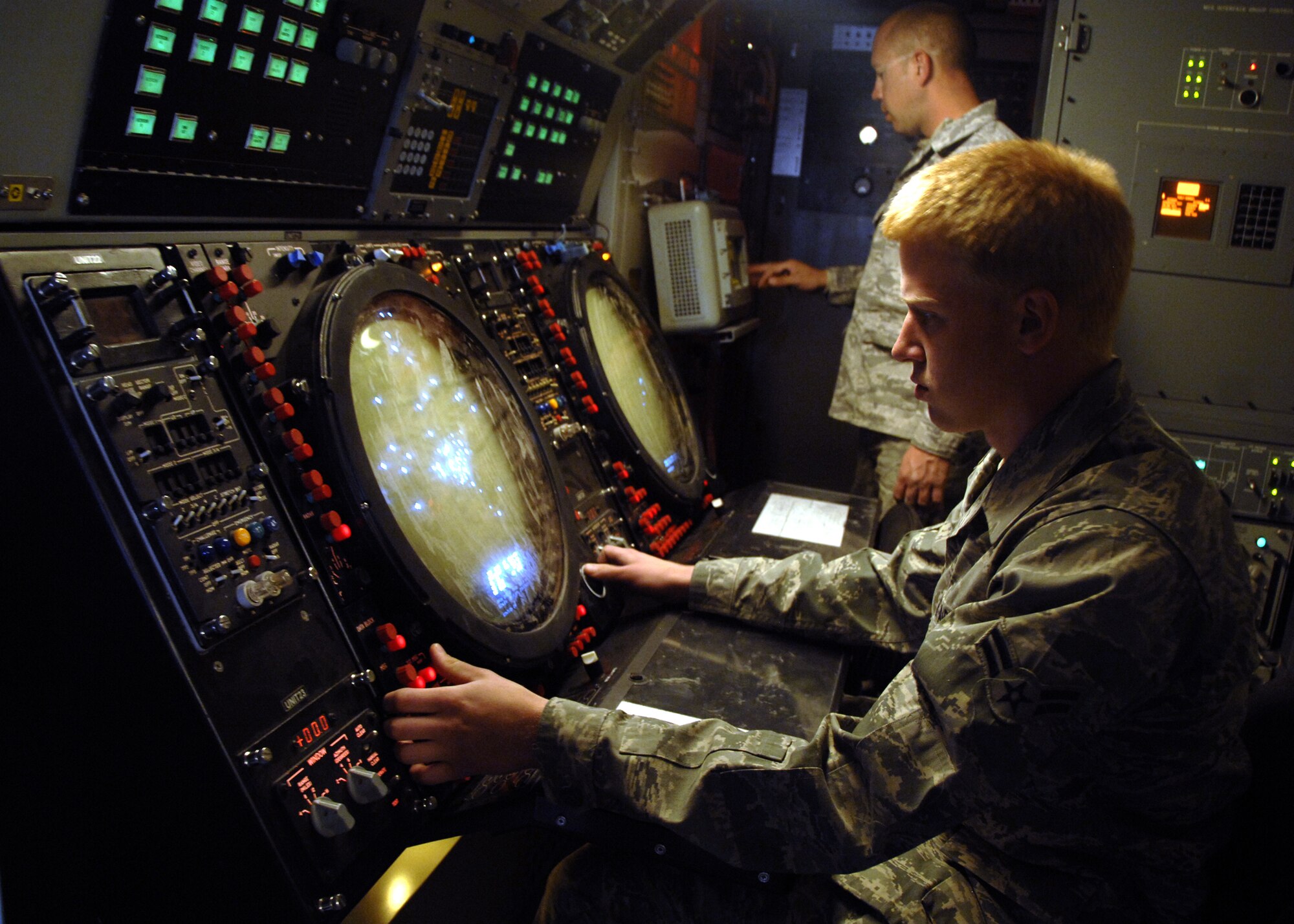 KANDAHAR AIRFIELD, Afghanistan -- Airman 1st Class Joseph Baran (front) performs height checks on planned position indicators while Tech. Sgt. Steven Russell (back) checks receiver gains on a radar control panel, Nov. 20, 2009. Performing these checks ensure aircraft height checks are correct and ensures proper amplifications are being transferred to video. Airman Baran and Sergeant Russell are ground radar maintainers with the 73rd Expeditionary Air Control Squadron from Mountain Home Air Force Base, Idaho. (U.S. Air Force photo/Senior Airman Timothy Taylor)
