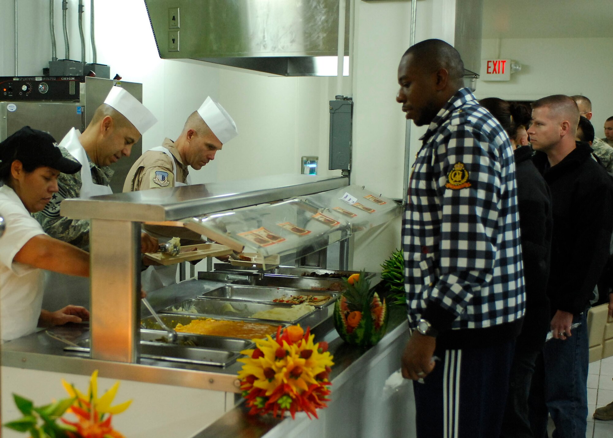 BAGRAM AIRFIELD, Afghanistan -- Chief Master Sgt. Jeffery Cui (left), 455th Air Expeditionary Wing command chief, and Brig. Gen. Steven Kwast (right), 455th Air Expeditionary Wing commander, serve food during a Thanksgiving day celebration, Nov. 26, 2009.  455th AEW's leadership served meals on Thanksgiving as a way to boost the morale of the servicemen and women.  (U.S. Air Force photo/Senior Airman Felicia Juenke)