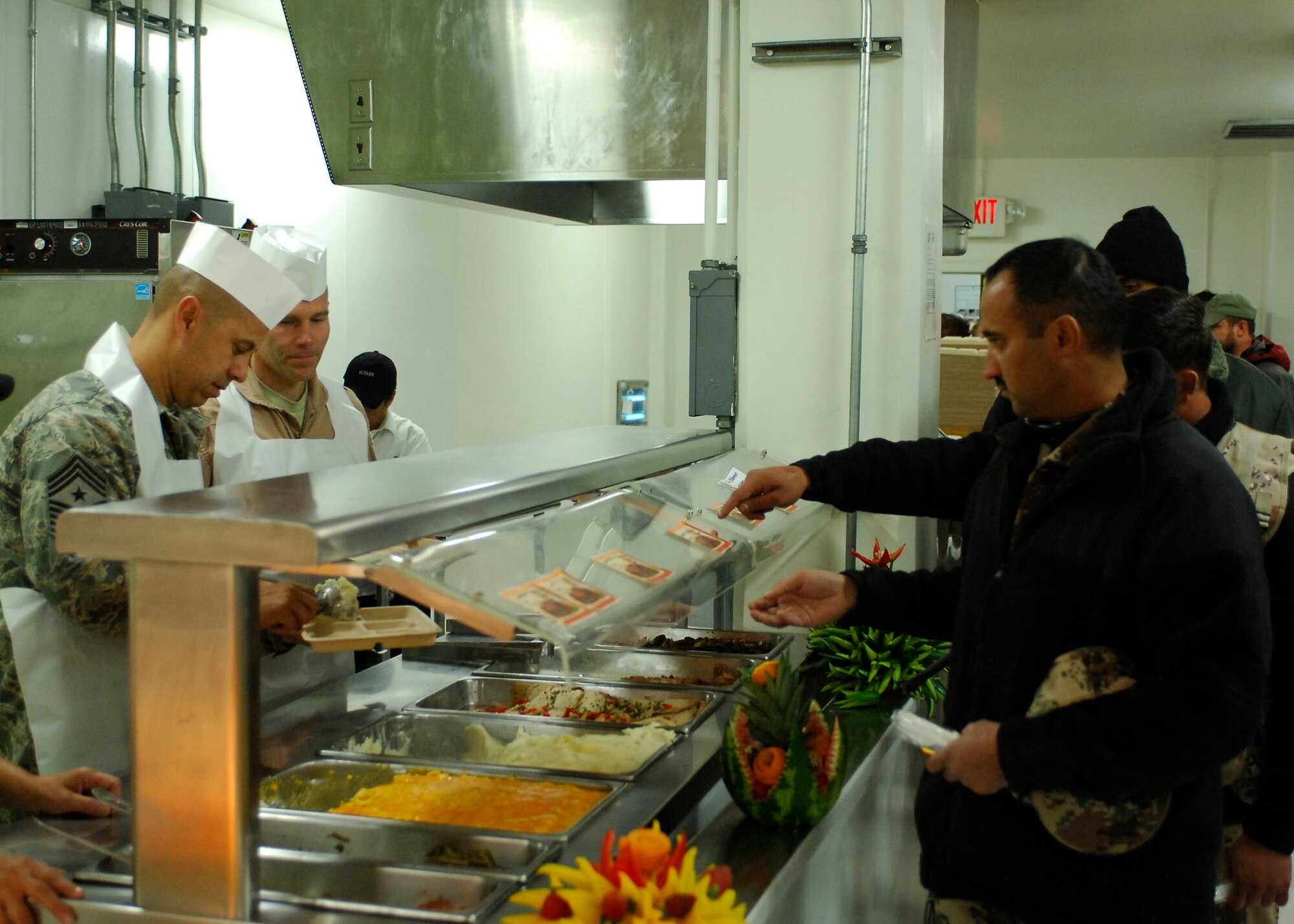 BAGRAM AIRFIELD, Afghanistan -- Chief Master Sgt. Jeffery Cui (left), 455th Air Expeditionary Wing command chief, and Brig. Gen. Steven Kwast (right), 455th Air Expeditionary Wing commander, serve food during a Thanksgiving day celebration, Nov. 26, 2009.  455th AEW's leadership served meals on Thanksgiving as a way to boost the morale of the servicemen and women.  (U.S. Air Force photo/Senior Airman Felicia Juenke)