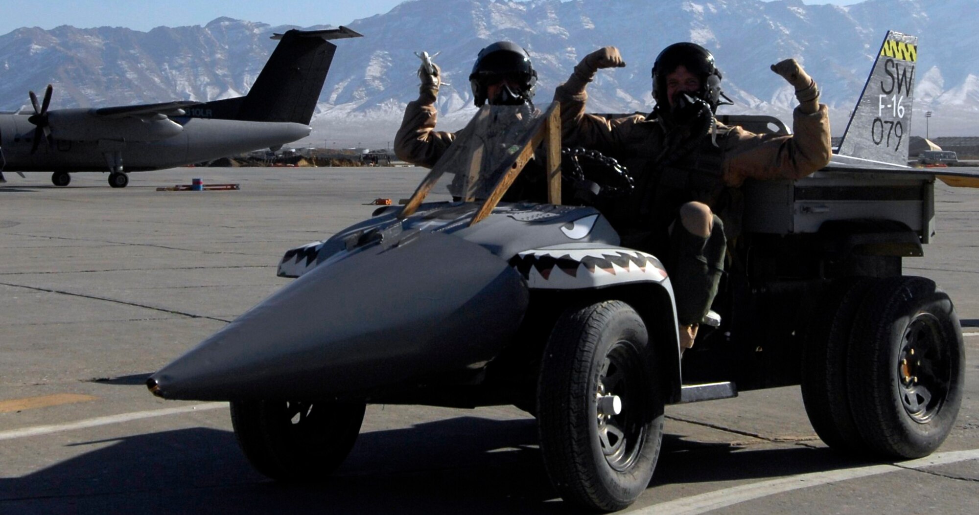 BAGRAM AIRFIELD, Afghanistan -- Capt. Aleksas Juskys (left) and 1st Lt. Casey Manning from the 79th Expeditionary Fighter Squadron drive all-terrain vehicle decorated as an F-16 Fighting Falcon drives by the flightline as part of a Thanksgiving Day parade Nov. 26, 2009. The F-16 was named the second place winner in the judging portion of the parade. The parade featured thirteen floats created during mission downtime as a recreation of the famous New York City event. (U.S. Air Force photo/Staff Sgt. J.G. Buzanowski)