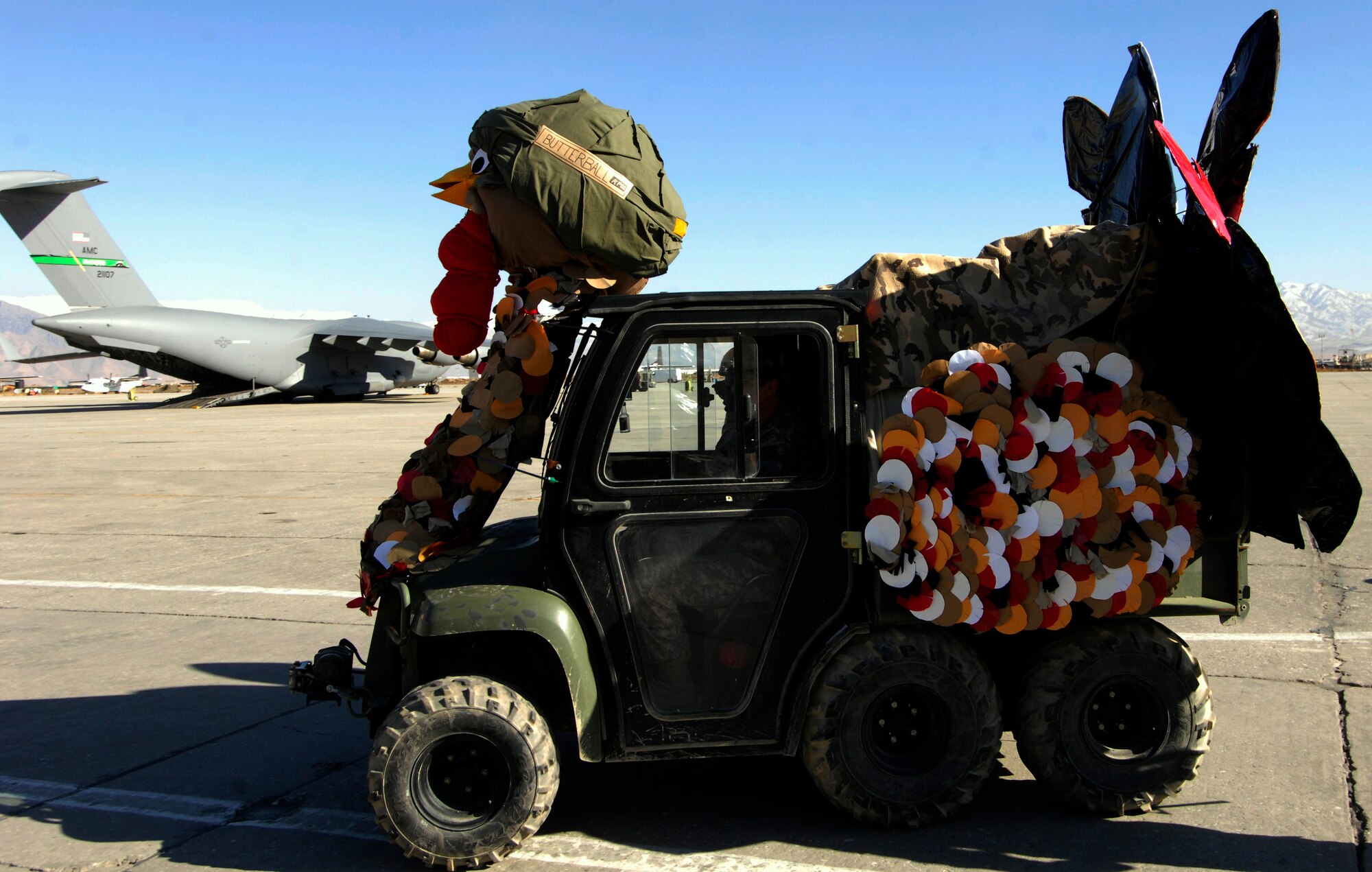 BAGRAM AIRFIELD, Afghanistan -- An all-terrain vehicle decorated as a combat turkey drives by the flightline as part of a Thanksgiving Day parade Nov. 26, 2009. The combat turkey float was named the first place winner in the judging portion of the parade. It was created by the joint 455th Contingency Aeromedical Staging Facility and Task Force Mountain Warrior team. (U.S. Air Force photo/Staff Sgt. J.G. Buzanowski)