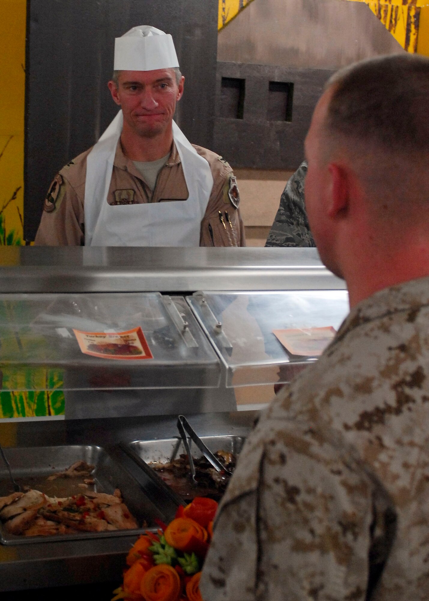BAGRAM AIRFIELD, Afghanistan -- Colonel Patrick McKenzie, 455th Expeditionary Operations Group commander, serves an Airman food during Thanksgiving, Nov. 26, 2009.  Air Force and Army leadership served meals on Thanksgiving as a way to boost the morale of the servicemen and women.  Col. McKenzie is deployed from Norfolk Naval Station, Va.  (U.S. Air Force photo/Senior Airman Felicia Juenke)