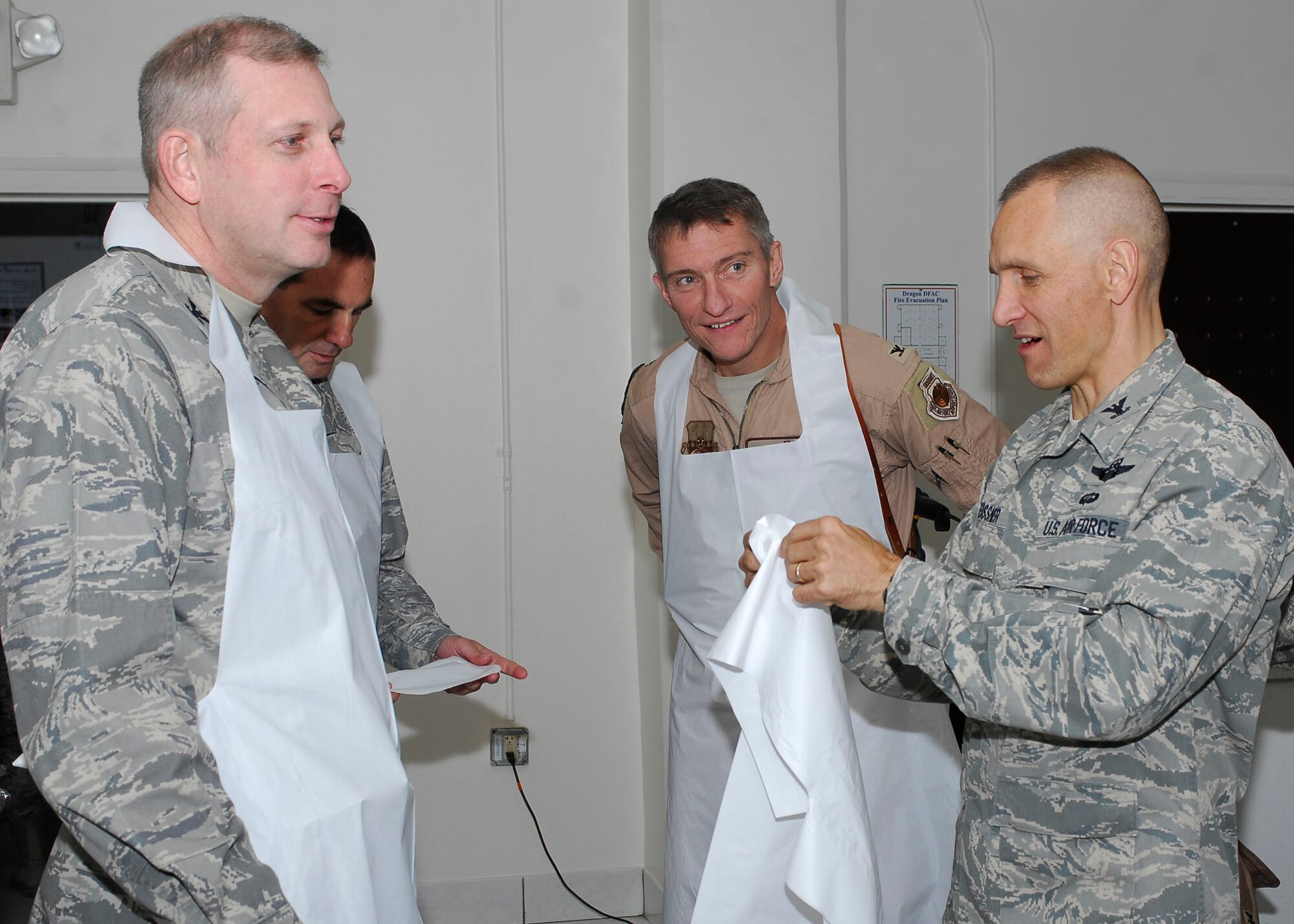 BAGRAM AIRFIELD, Afghanistan -- (From left to right) Colonel Christopher Pike, Col. Lawrence Gatti, Col. Patrick McKenzie, and Col. James Beissner don aprons and hats before serving a Thanksgiving meal to Airmen, Soldiers, Sailors and Marines, Nov. 26, 2009.  The Air Force and Army leadership served meals on Thanksgiving as a way to boost the morale of the servicemen and women.  Col. Pike, the 455th Expeditionary Mission Support Group commander, is deployed from Elmendorf Air Force Base, Alaska.  Col. Gatti, the 455th Expeditionary Maintenance Group commander, is deployed from Langley AFB, Va.  Col. McKenzie, the 455th Expeditionary Operations Group commander, is deployed from Norfolk Naval Station, Va.  Col. Beissner, the 455th Air Expeditionary Wing vice commander, is deployed from Langley AFB, Va.  (U.S. Air Force photo/Senior Airman Felicia Juenke)