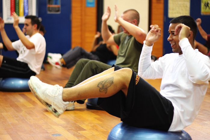 Lance Cpl. Jacob Moore balances on a Bosu during a grueling aerobics session, called the Turkey Burn, Nov. 27. The Bosu is a contraption resembling half of a beach ball — a really big beach ball — fixed to a circular plastic base.
