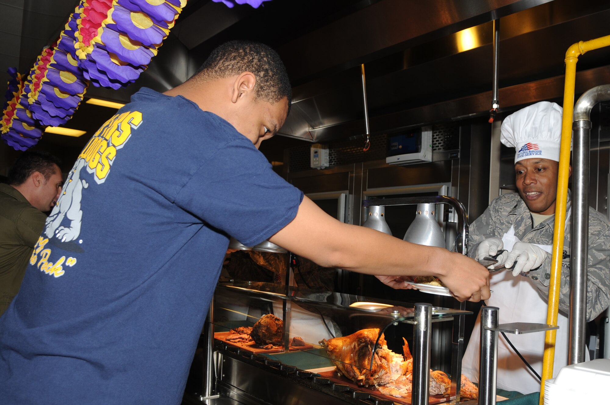 Airman LaVel Sterling, 31st Fighter Wing photographer, is being served turkey by Brig. Gen. C.Q. Brown Jr., 31st FW commander, during the Thanksgiving dinner meal at the La Dolce Vita dining facility Nov.26, 2009 at Aviano Air Base, Italy. For the more than 700 Airmen who live in the nearby dormitories, the Thanksgiving meal brings back a lot of memories of Thanksgivings past spent with family and friends from home, playing games in the back yard, and watching their favorite TV programs together.  (U.S. Air Force photo/ Staff Sgt. Mercedes Crossland)