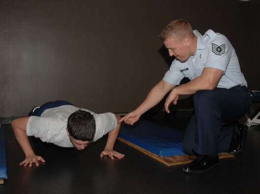 ANDERSEN AIR FORCE BASE, Guam - (Right) Tech. Sgt. Jason Herman, nutrition program manager for the health and wellness center, gives feedback to Senior Airman Jonathan Ardis, 36th Force Support Squadron fitness specialist, on his push-up form here Nov. 30. Correct push-up form is one of many focus areas on the new physical training standards that will be implemented throughout the Air Force July 1. (U.S. Air Force photo by Senior Airman Shane Dunaway)