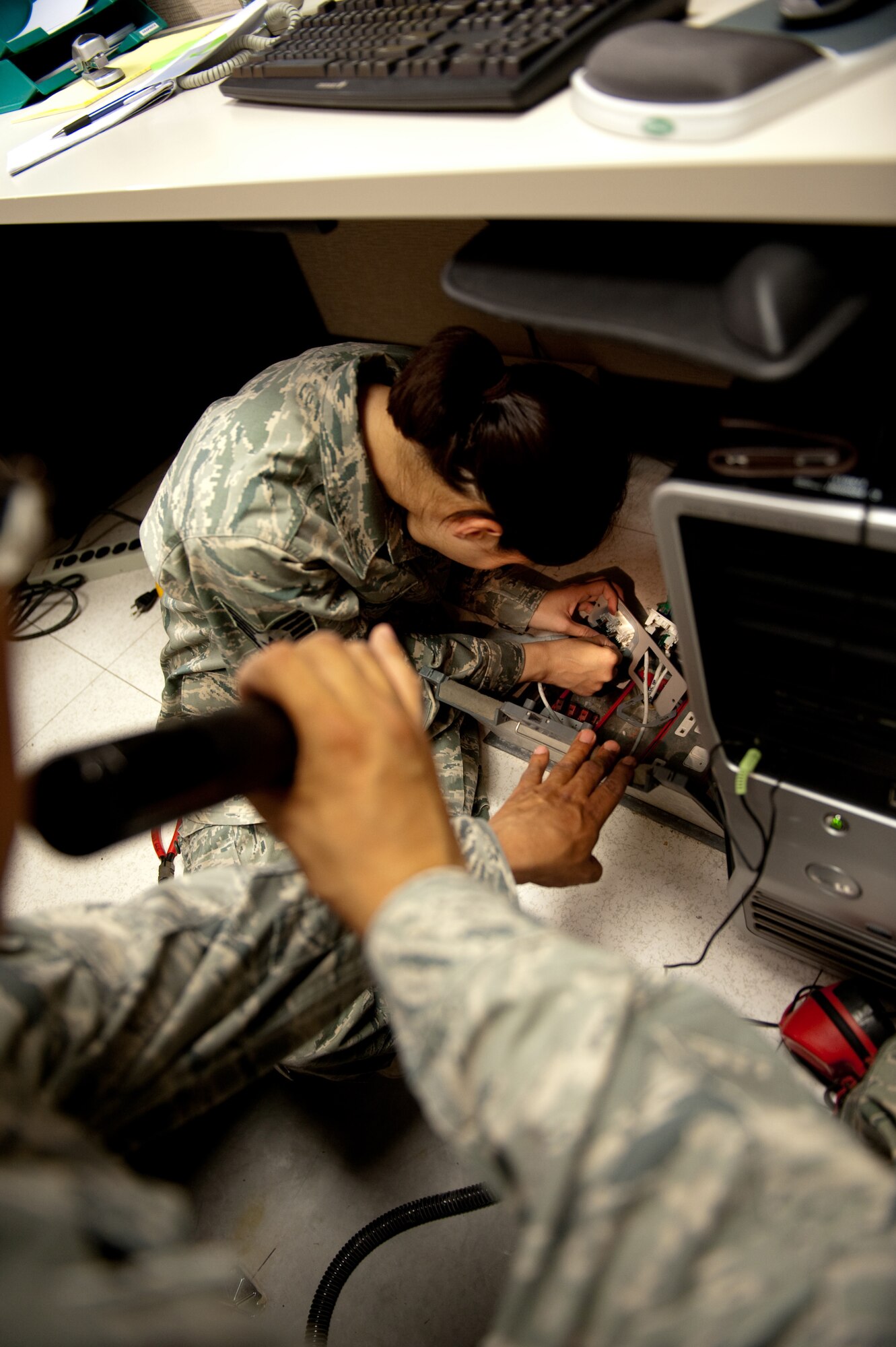 Staff Sgt. Grace Spoerle, 379th Expeditionary Communications Squadron telephone systems repair craftsman, creates a terminal connection for a Category 5 cable, Nov. 27, in Southwest Asia. Sergeant Spoerle helps to keep telephones, computers and other communication systems operating correctly. (U.S. Air Force photo/Staff Sgt. Robert Barney) 