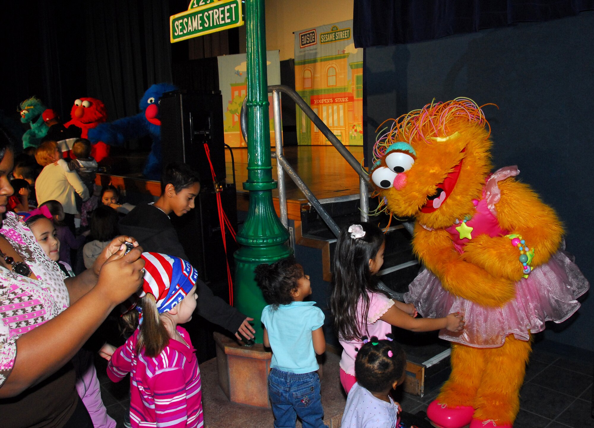 Sesame Street's Zoe steps off stage to meet children of military families during a USO sponsored show Nov. 28 at Eielson Air Force Base, Alaska. The free Sesame Street/USO Experience is a live character tour and part of Sesame Street's talk, listen, connect initiative for military families. (U.S. Air Force photo/Tech. Sgt. Shad Eidson)