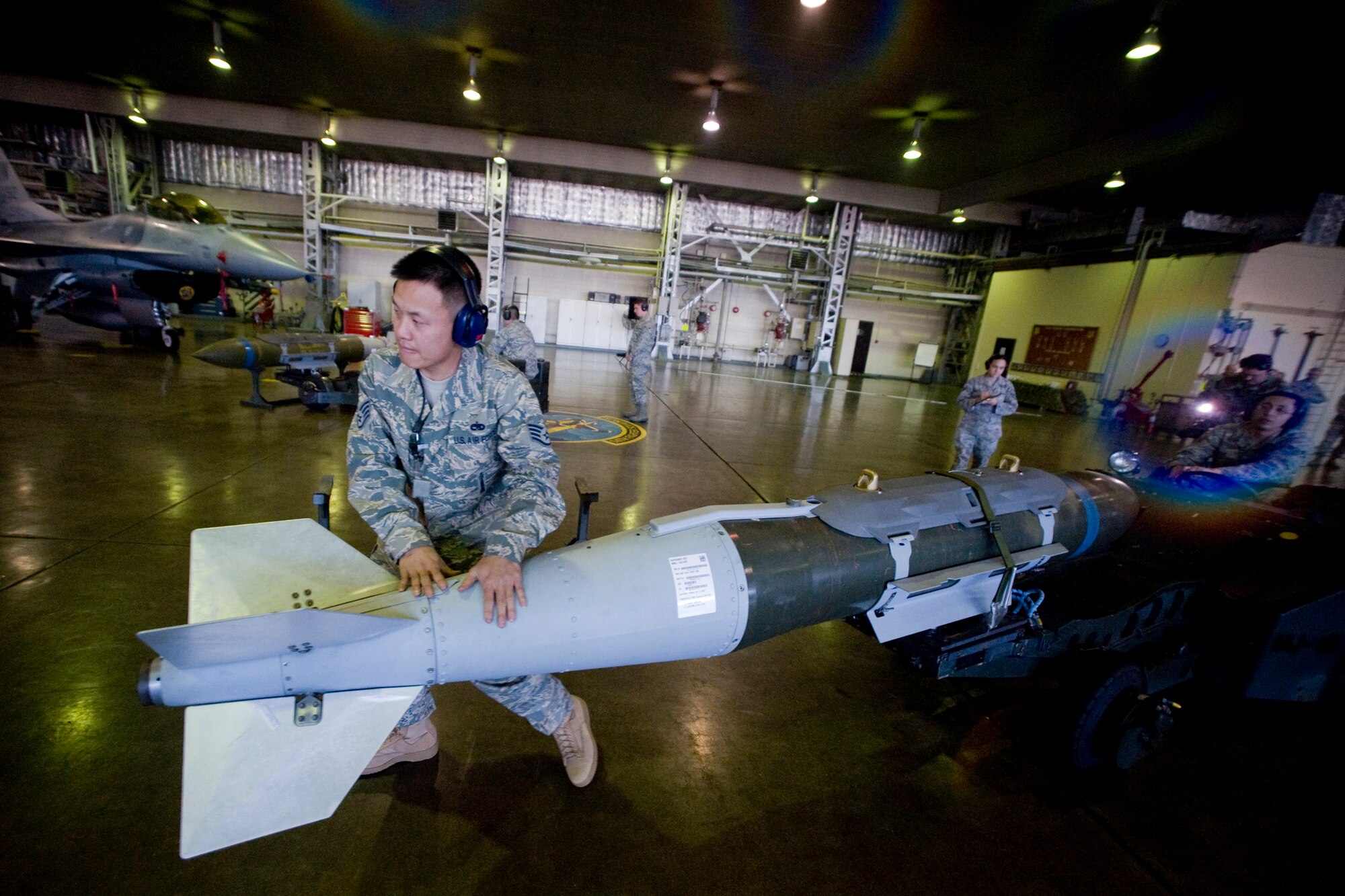 MISAWA AIR BASE, Japan -- Staff Sgt. David Hsu and Airman 1st Class Neo Leon, 14th Aircraft Maintenance Unit load-crew members, transport a GBU-31 joint direct attack munition during a weapons-load crew of the year competition Nov. 25 at Hangar 911. The team raced against two load crews out of the 13th Aircraft Maintenance Unit and beat out more than 20 load crews for a chance to compete in the finals. (U.S. Air Force photo/Senior Airman Jamal D. Sutter)