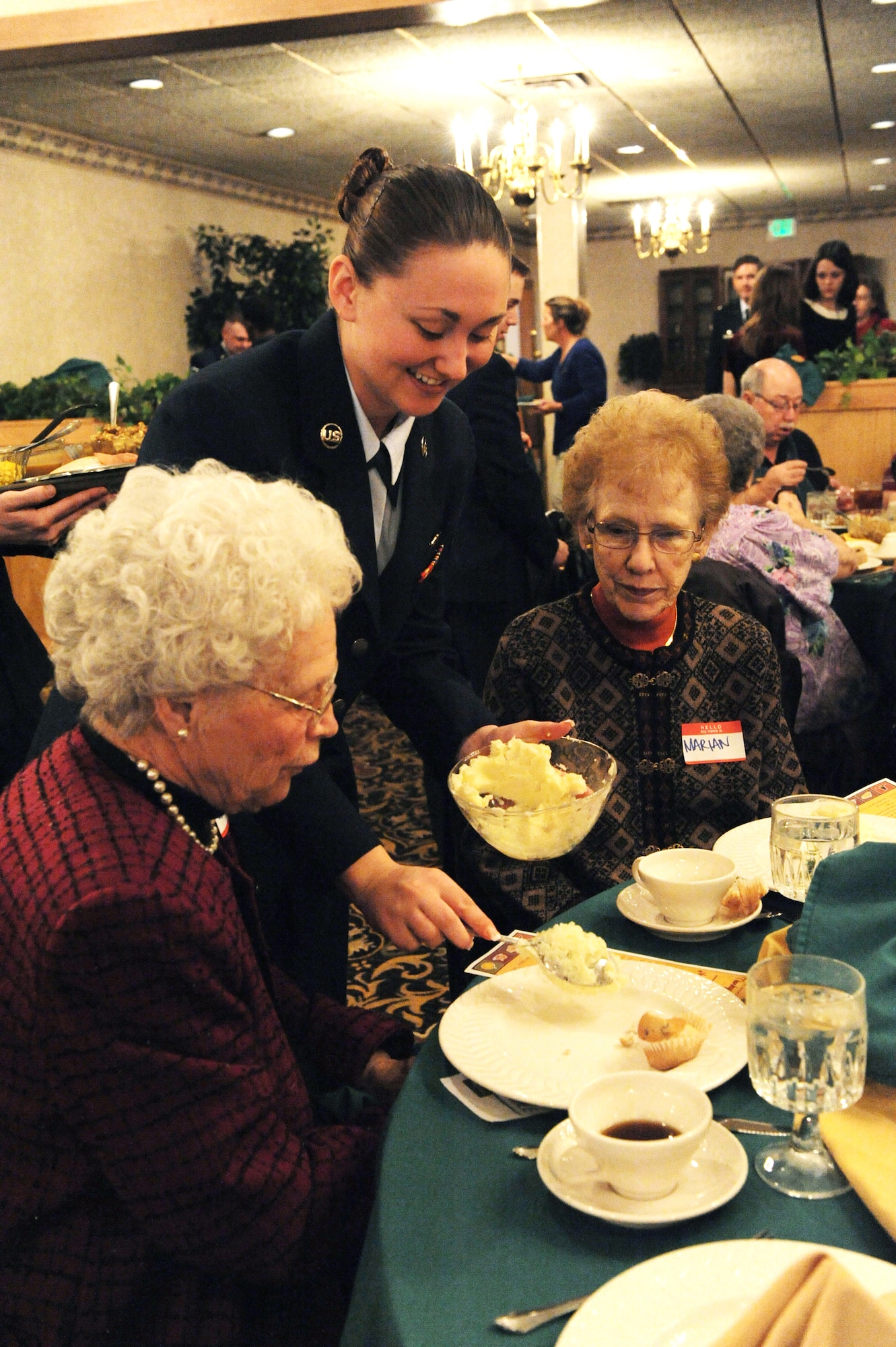MINOT AIR FORCE BASE, N.D. -- Airman 1st Class Jessica Kloth-Fay, 5th Force Support Squadron force management clerk, serves up a free Thanksgiving meal to a group of Minot senior citizens during the base’s annual “Day of Love” celebration here Nov. 26. The base has hosted the Day of Love since 1969, and its popularity with the base and local community has made it a long-standing tradition ever since. (U.S. Air Force photo by Airman 1st Class Jesse Lopez)