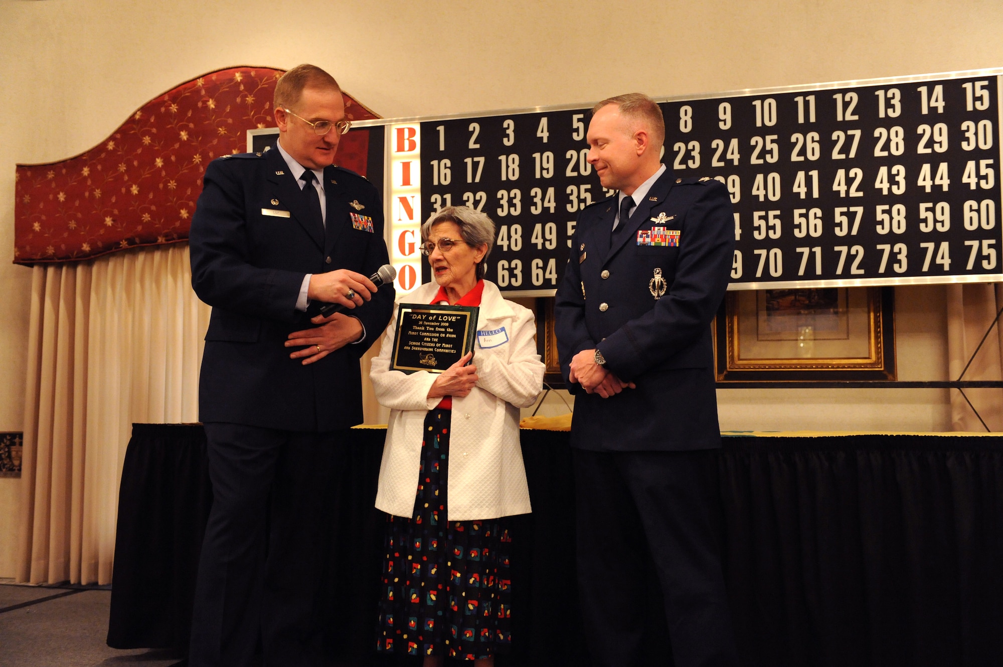 MINOT AIR FORCE BASE-- Col. Douglas Cox, 5th Bomb Wing commander, and Col. Ferdinand Stoss, 91st Missile Wing commander, present Ann with a certificate of appreciation on behalf of the Minot Commission On Aging and the senior citizens of Minot and the surrounding communities during the base’s annual “Day of Love” celebration here Nov. 26. The base has hosted the Day of Love since 1969, and its popularity with the base and local community has made it a long-standing tradition ever since. (U.S. Air Force photo by Airman 1st Class Jesse Lopez)