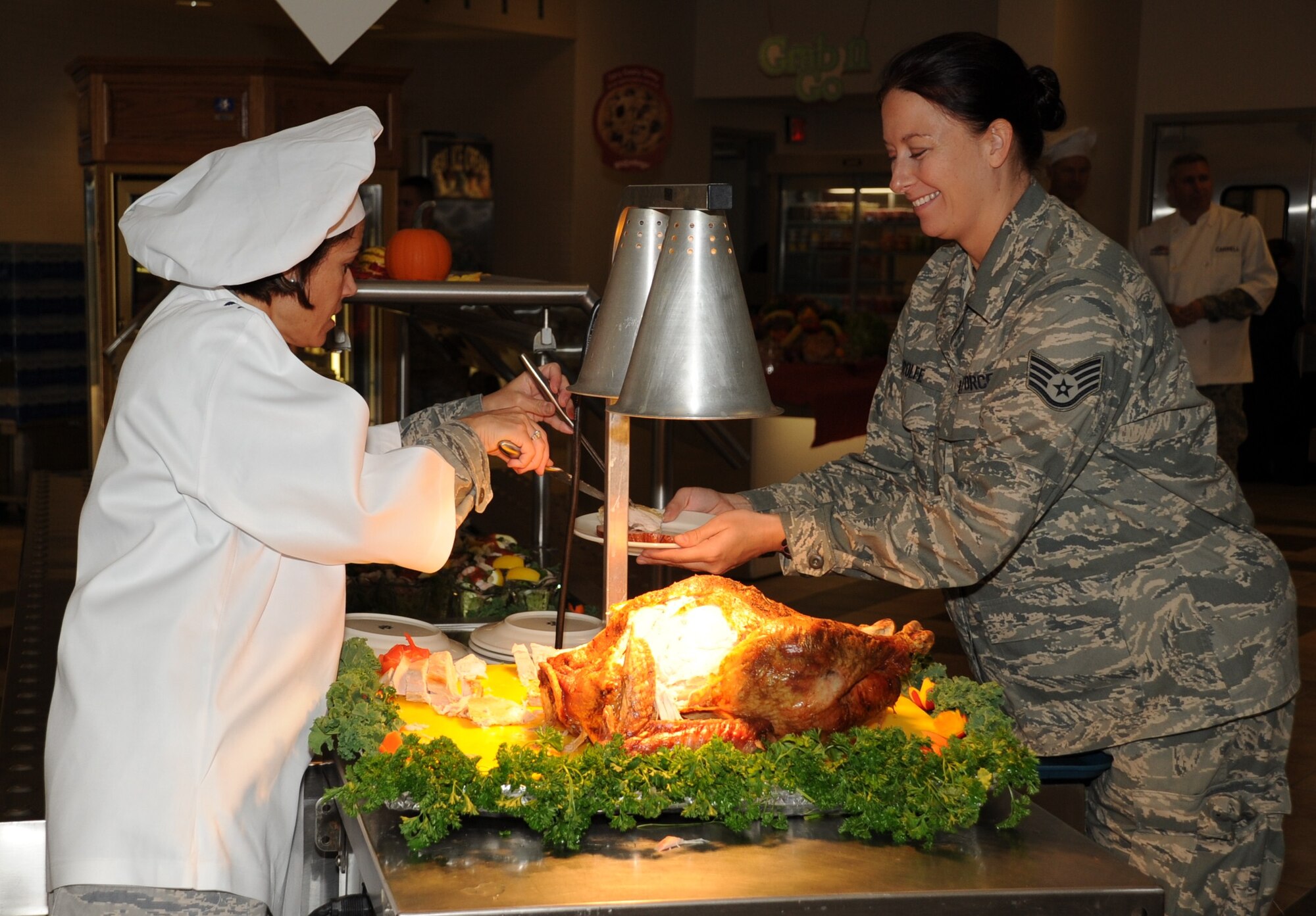 Col. Gina Grosso, Joint Base McGuire-Dix-Lakehurst commander, offers turkey to an Airman during the JBMDL Thanksgiving dinner Nov. 26 here. Thanksgiving dinners were held at dining facilities on McGuire and Dix. (U.S. Air Force photo/Angel Lopez)