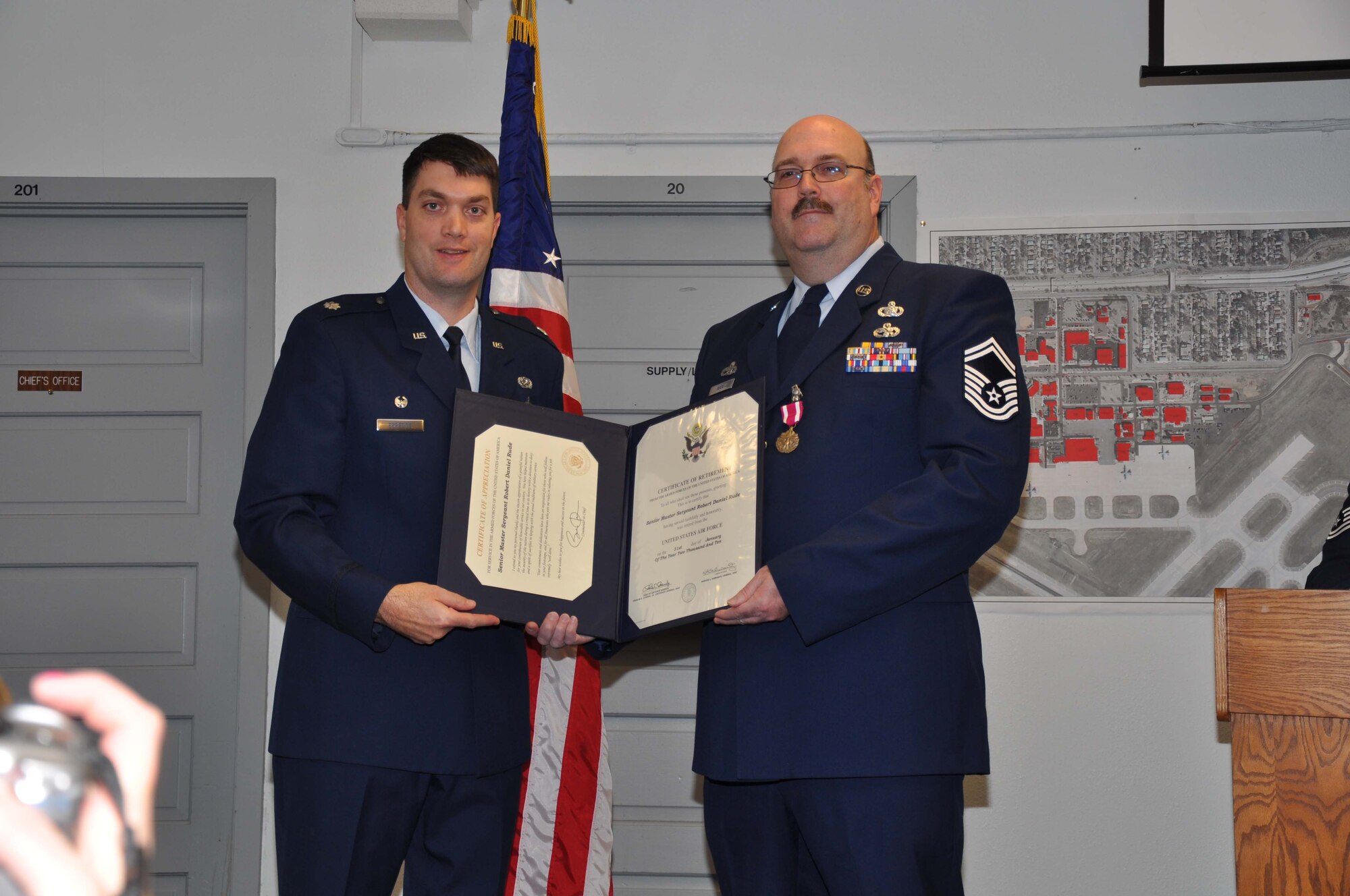 Senior Master Sgt. Dan Rude receives his retirement certificate from Lt. Col. Rick Erredge, 934th Communications Flight commander. (Air Force Photo/Tech. Sgt. Bob Sommer)