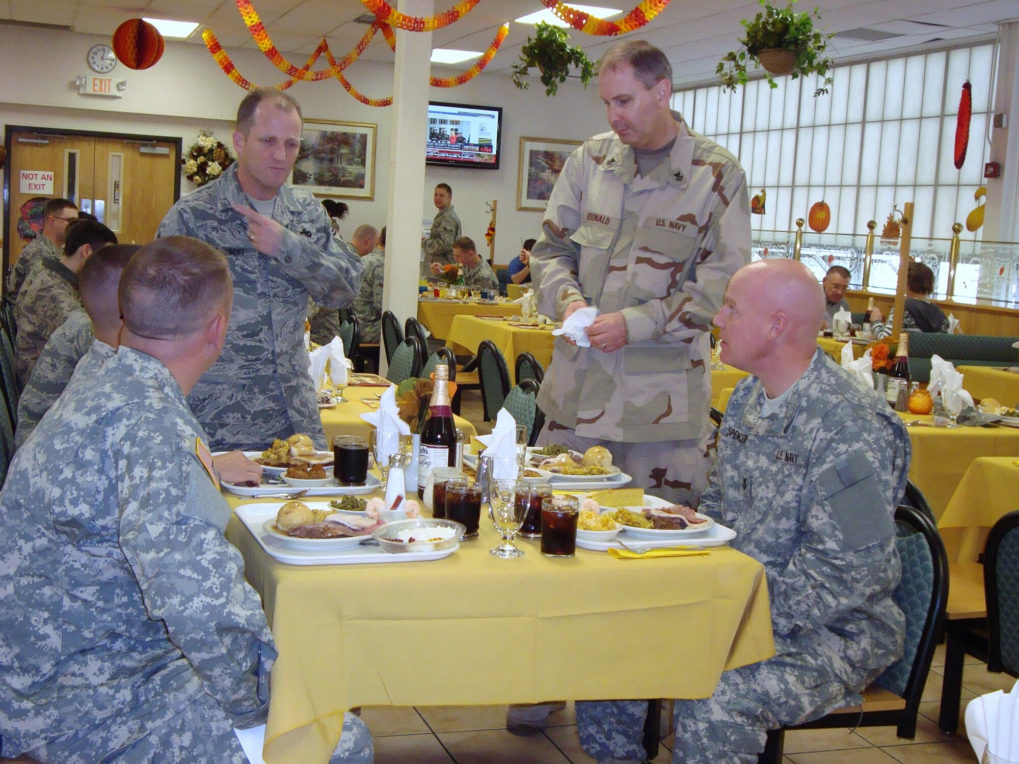 Airmen, Sailors and Soldiers share a table with all the holiday trimmings and enjoy a Thanksgiving dinner at the Dix dining facility Nov. 26 here. Joint Base McGuire-Dix-Lakehurst leadership served dinner to the troops  on base on Thanksgiving Day (U.S. Air Force photo/Angel Lopez).