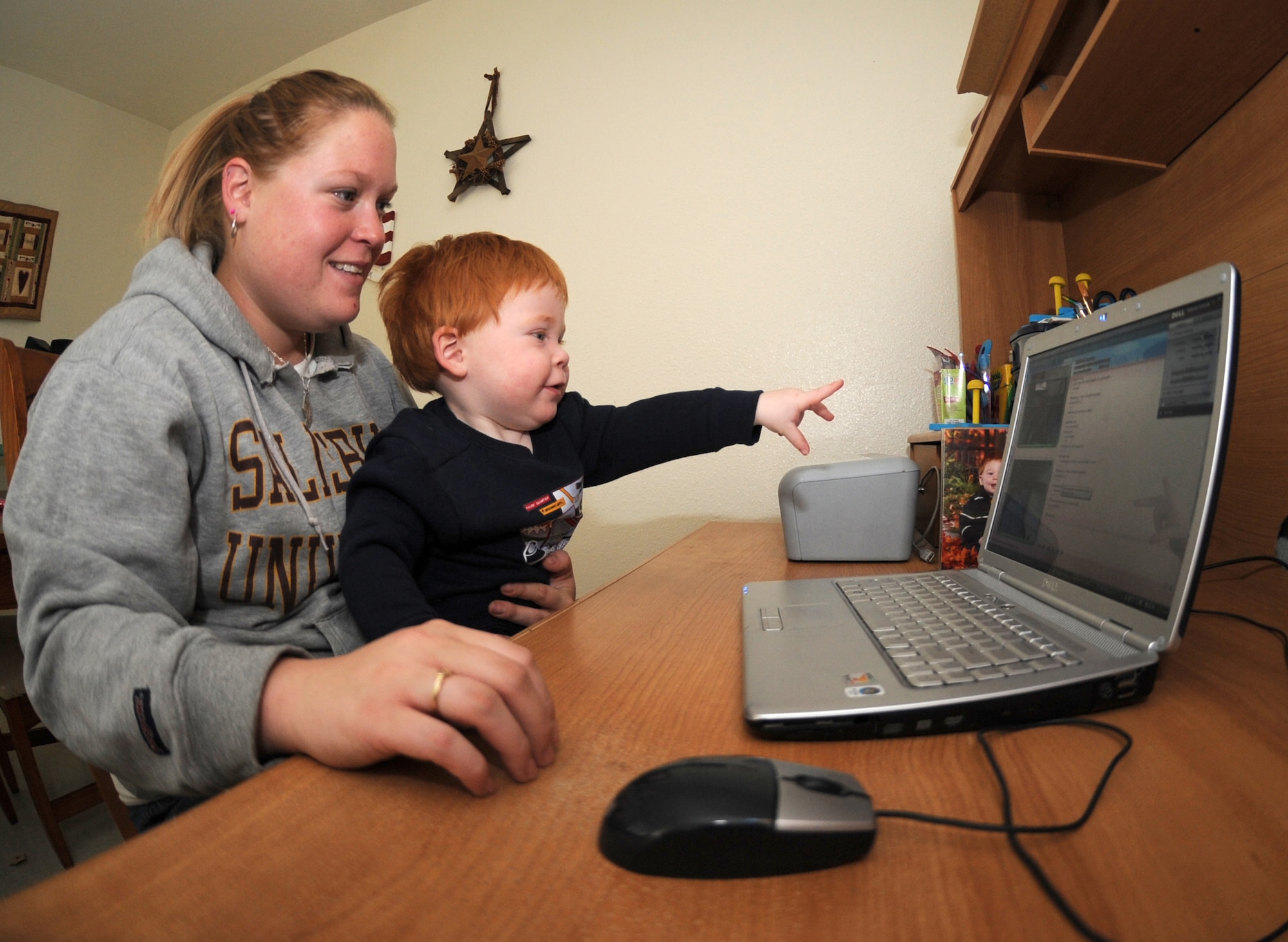 HOLLOMAN AIR FORCE BASE, N.M. -- Ashley* speaks with her deployed husband over Web cam as her one-year-old son points to "daddy" on the computer screen, Nov. 19. Ashley, like other military spouses, manages the home front in her husband's absense and said she looks forward to his return. *Last name omitted for safety and security reasons. (U.S. Air Force photo by Airman 1st Class Sondra Escutia)