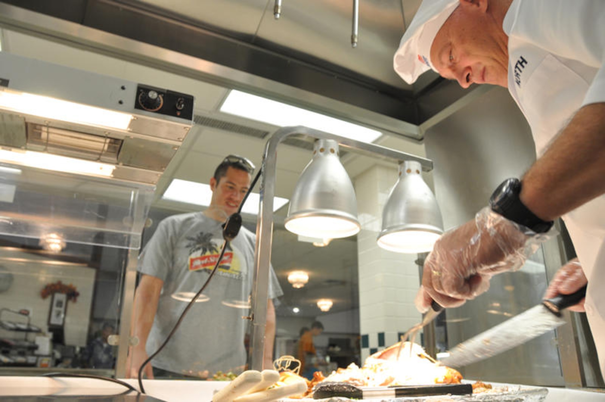 Gen. Gary North, Pacific Air Forces commander, carves turkey for Staff Sgt. James Loew, 735th Air Mobility Squadron, at the Hale Aina Dining Facility Nov. 26 at Hickam Air Force Base, Hawaii. Turkey, prime rib and all the trimmings were available to Hickam Airmen, dependents, visiting family members and retirees for Thanksgiving. General North was joined by senior leadership from 13th Air Force, the 15th Airlift Wing and several members of the Air Force Civilian Advisory Council. The facility prepared food in anticipation of nearly 400 guests. (Department of Defense photo/Tech. Sgt. Cohen A. Young)