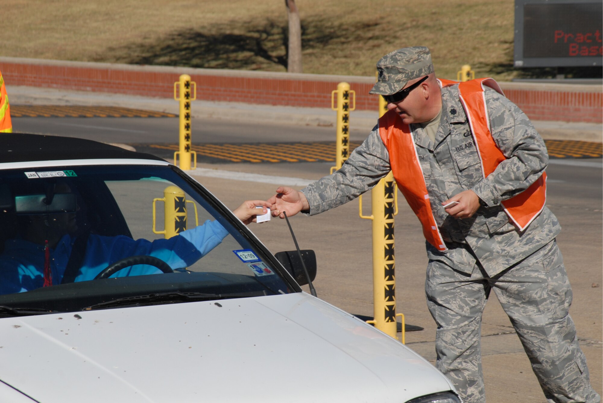 GOODFELLOW AIR FORCE BASE, Texas -- Lt. Col. Scott Shuttleworth, 17th Mission Support Group deputy commander, hands out Wingman cards to Goodfellow members as they leave for the holiday weekend, Nov. 25, 2009. Wing leadership manned the north and south gates reminding members to keep their focus on safety and risk management during the extended four-day weekend. (U.S. Air Force photo/Staff Sgt. Laura R. McFarlane)