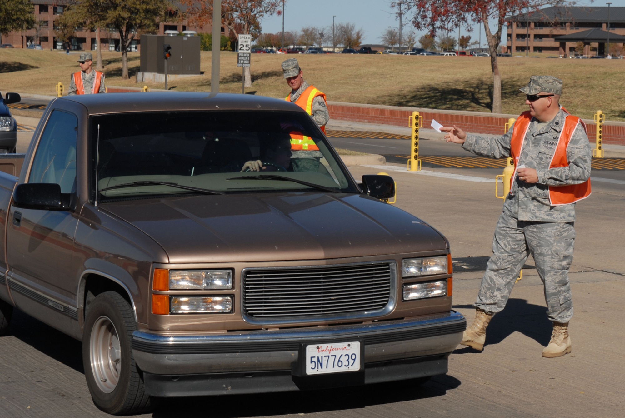 GOODFELLOW AIR FORCE BASE, Texas -- Lt. Col. Scott Shuttleworth, 17th Mission Support Group deputy commander, hands out Wingman cards to Goodfellow members as they leave for the holiday weekend, Nov. 25, 2009. Wing leadership manned the north and south gates reminding members to keep their focus on safety and risk management during the extended four-day weekend. (U.S. Air Force photo/Staff Sgt. Laura R. McFarlane)