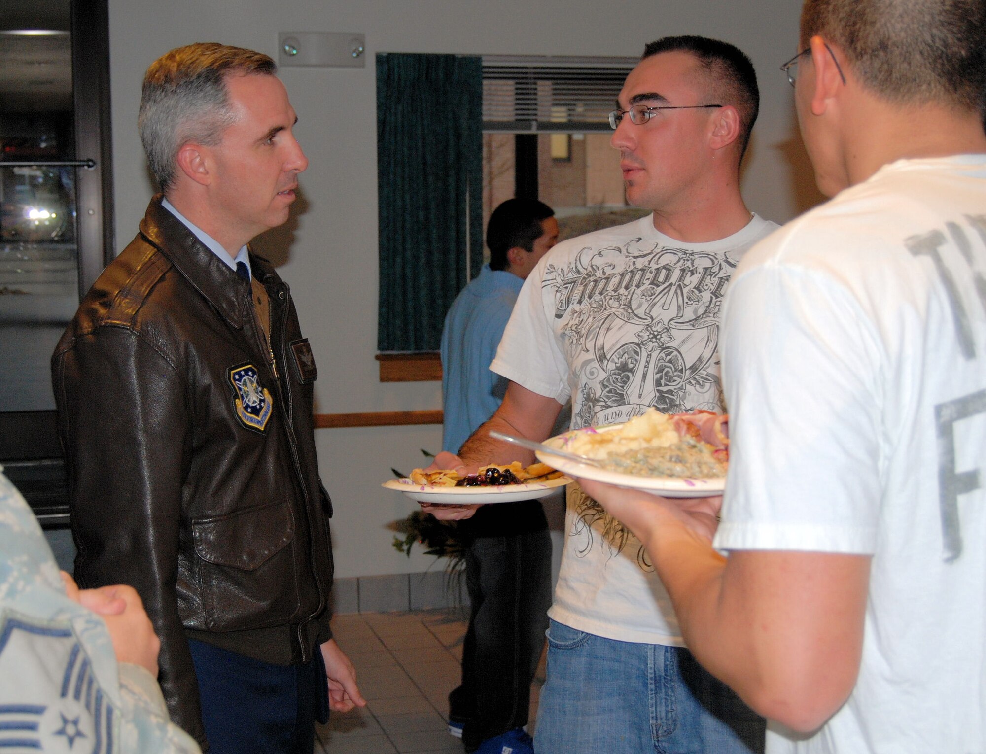 Col. Stephen N. Whiting, 21st Space Wing commander, speaks with Airman 1st Class Jonathan Francis, 21st Security Forces Squadron, at the annual Thanksgiving Meal Nov. 20. This Peterson tradition provides a holiday meal to single Airmen living in the base dorms and gives them an opportunity to interact with wing leadership. (Air Force photo by Airman 1st Class Jessica Hines)  