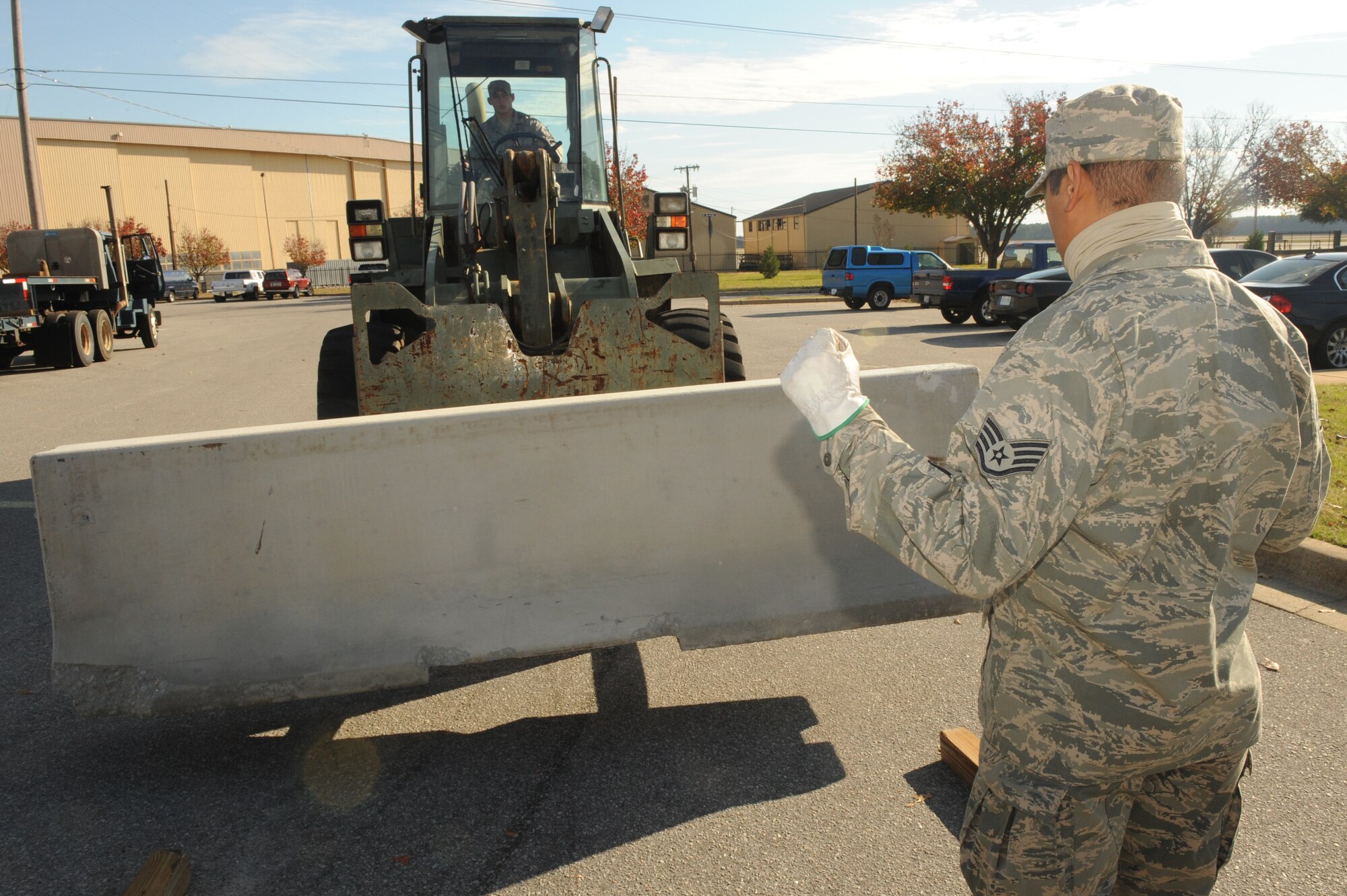 SHAW AIR FORCE BASE, S.C. -- Staff Sgt. Edson Aglibut, 20th Civil Engineer Squadron, directs proper placement of a barricade during Shaw's Phase I operational readiness exercise, Sea Lion 10-01, Nov. 30.  Airmen of the 20th CES place barriers to protect certain facilities as part of a module plan during Shaw's exercise. (U.S Air Force photo/Senior Airman David Minor)