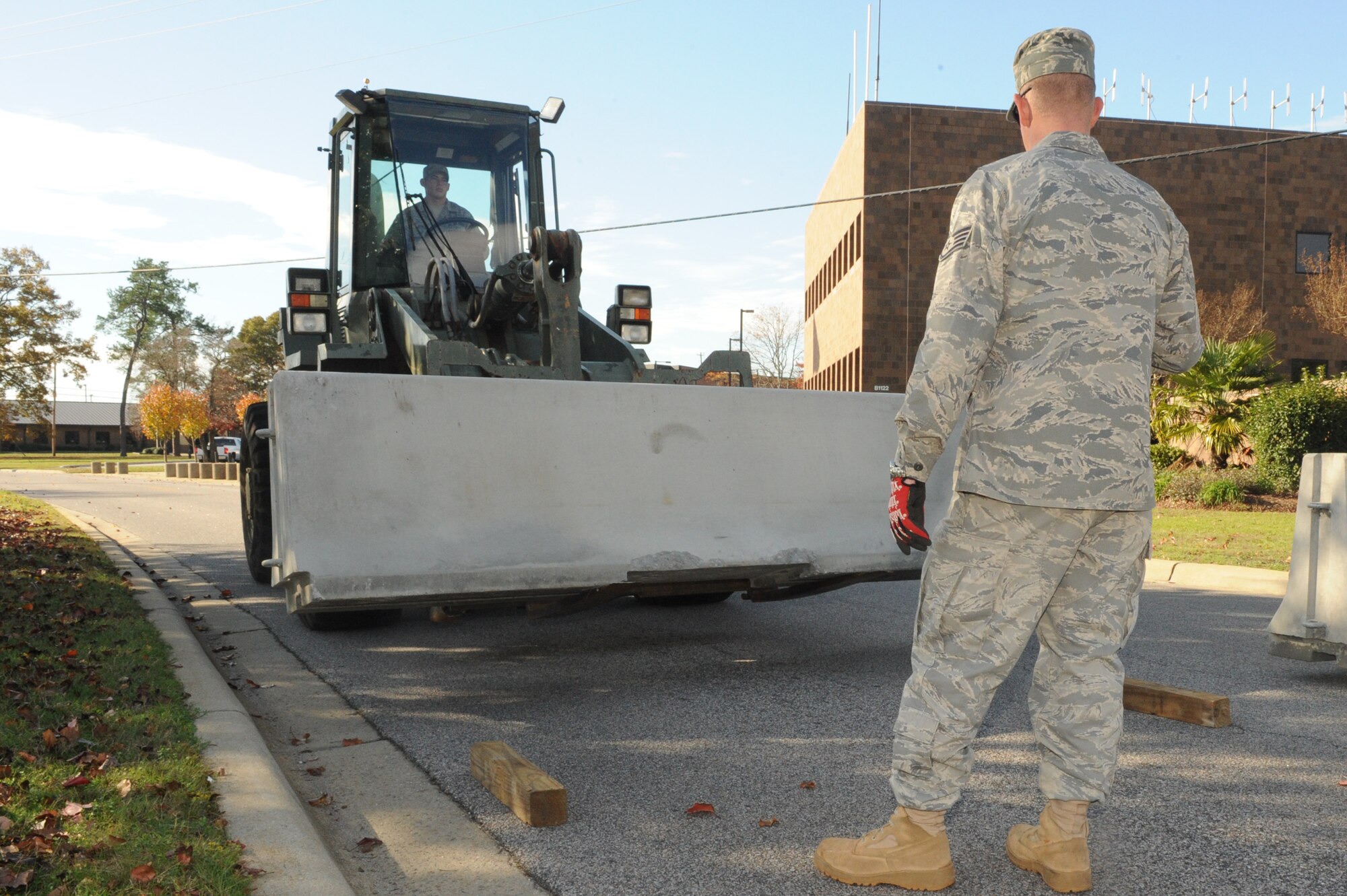 SHAW AIR FORCE BASE, S.C. -- Staff Sgt. Patrick Holland, 20th Civil Engineer Squadron, directs proper placement of a barricade during Shaw's Phase I operational readiness exercise Sea Lion 10-01, Nov. 30.  Airmen of the 20th Civil Engineer Squadron place barriers to protect certain facilities as part of a module plan during the exercise. (U.S Air Force photo/Senior Airman David Minor)