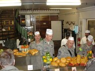 SEYMOUR JOHNSON AIR FORCE BASE, N.C. --   Chief Master Sergeant David Jackson (left), a Reservist with the 916th Aircraft Maintenance Squadron, serves up a holiday meal along with other supervisors at Camp Eggers, Kabul, Afghanistan. The dining facility staff cooked the traditional Thanksgiving meal and camp leadership helped serve.                         