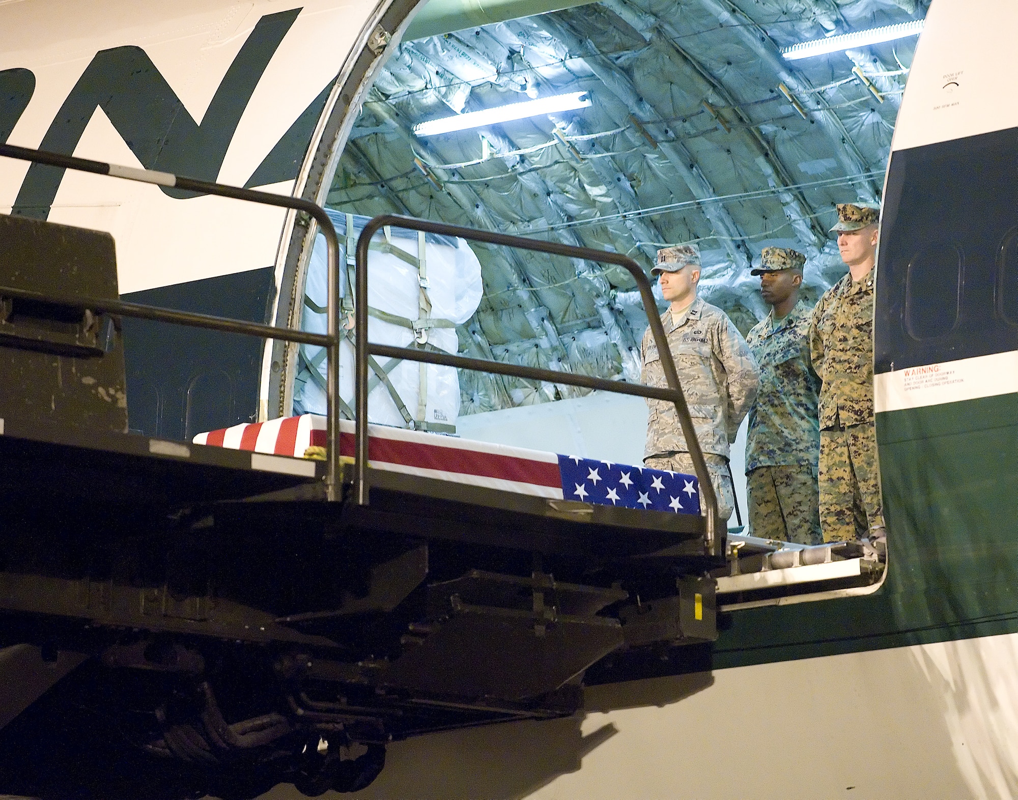 The remains of Lance Cpl. Nicholas J. Hand of Kansas City, MO., await transfer by a  U.S. Marine carry team at Dover Air Force Base, Del., November 24, 2009. Lance Cpl. Hand, 20, died Nov. 22 while supporting combat operations in Helmand province, Afghanistan.  He was assigned to 2nd Battalion, 2nd Marine Regiment, 2nd Marine Division, II Marine Expeditionary Force, Camp Lejeune, N.C. (USAF Photo by Brianne Zimny)