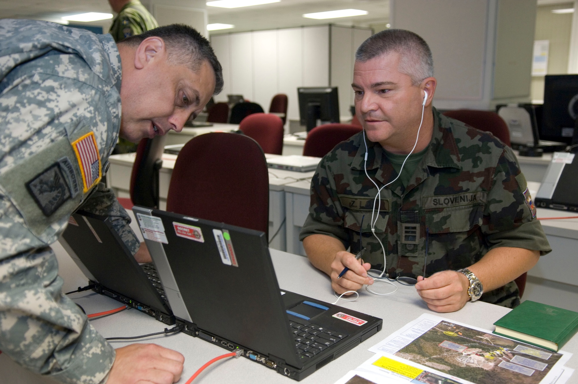 Military analysts discuss friendly forces interoperability during Bold Quest 2009. Bold Quest is an Advanced Concept Technology Demonstration and brings together nearly 1,000 professional warfighters and contractors from 11 countries and across the U.S. military to test the in a field environment the technologies designed to eliminate fratricide on the battlefield and refine the emerging technology behind Digitally Aided Close Air Support. (DoD Photo by: Staff Sgt. Vanessa Valentine, USAF)