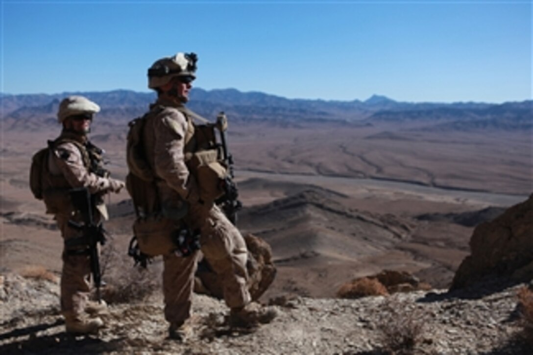 U.S. Navy Chief Petty Officer Anthony Geron (left) a hospital corpsman and Petty Officer 3rd Class Nicholas Becker, both with India Company, 3rd Battalion, 4th Marine Regiment, look out from a mountain north of Golestan, Afghanistan, on Nov. 25, 2009.  Marines and sailors patrol the mountain to find caves and hiding spots used by insurgents.  