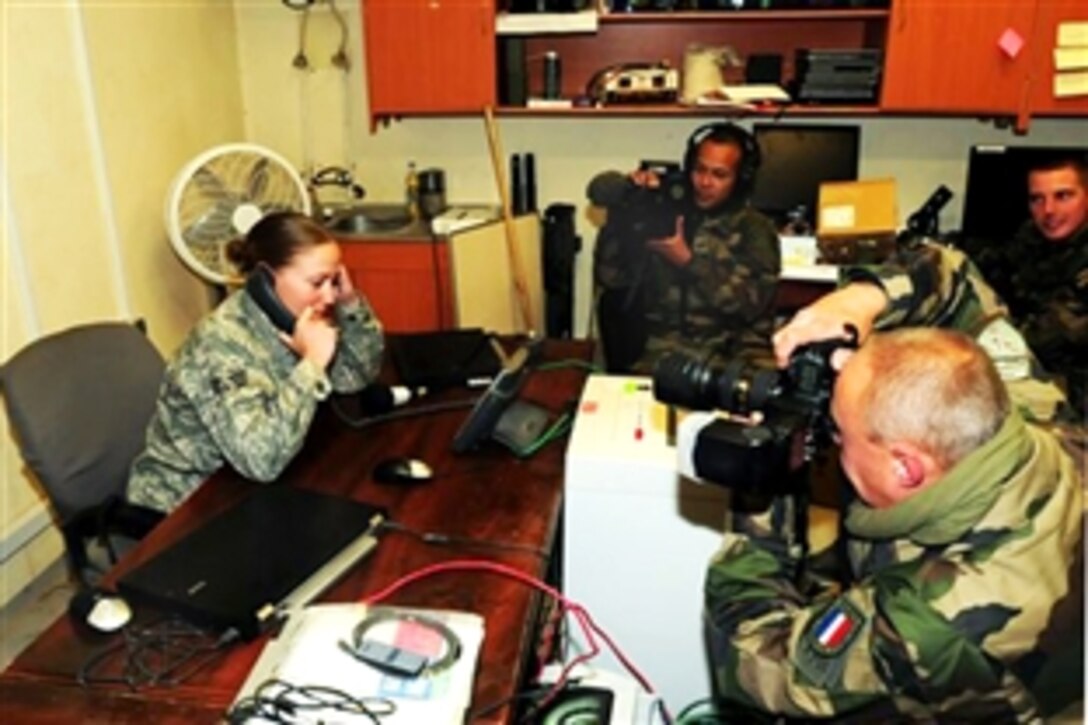 Senior Airman Ashley Jackson receives Thanksgiving greetings by phone from President Barack Obama as French forces film the conversation on Forward Operating Base Morales-Frazier, Afghanistan, Nov. 26, 2009. Jackson is a medic assigned to Provincial Reconstruction Team Kapisa