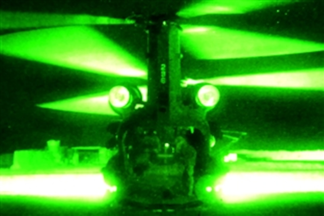 As seen through a night-vision device, a U.S. Army CH-47 Chinook helicopter awaits  international security forces in Afghanistan before launching a mission in Wardak province, Afghanistan, Nov. 19, 2009.