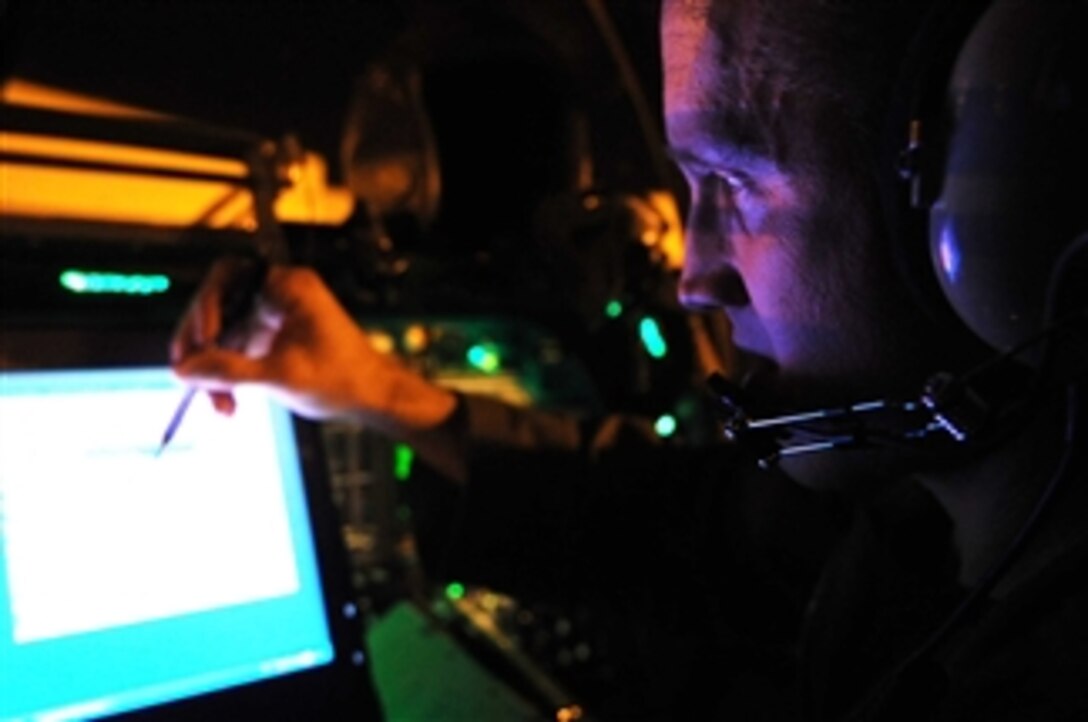 U.S. Air Force Maj. Chris Lovegren, a pilot with the 34th Bomb Squadron, operates the beyond line of sight system (BLOS) of a B-1B Lancer bomber during his preflight checklist at Ellsworth Air Force Base, S.D., on Nov. 23, 2009.  The BLOS system is capable of providing a variety of information including high-resolution terrain mapping.  