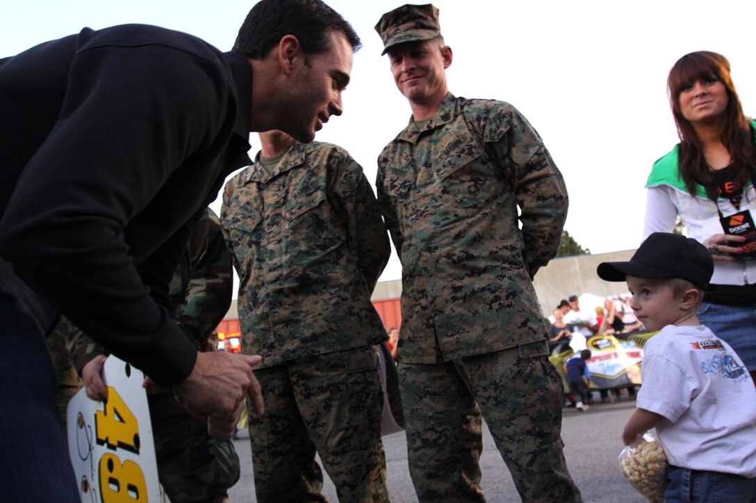 Jimmie Johnson, NASCAR’s 2009 Sprint Cup Series champion and the first driver to win four consecutive championship titles, interacts with and signs autographs for Marines, sailors and their families in front of Mainside’s Bowling Alley, Nov. 30.