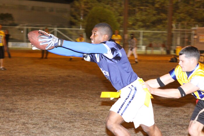 Gregory Banks, Hawks running back, extends the ball forward to gain any extra yardage he can get as the Ready Group’s corner Jameson Hastings grabs his flags during an intramural flag football game at Northside football field here Monday. The Hawks went on to win 19-13 after going into double overtime. The Hawks’ win breaks a three-game winning streak for the Ready Group.