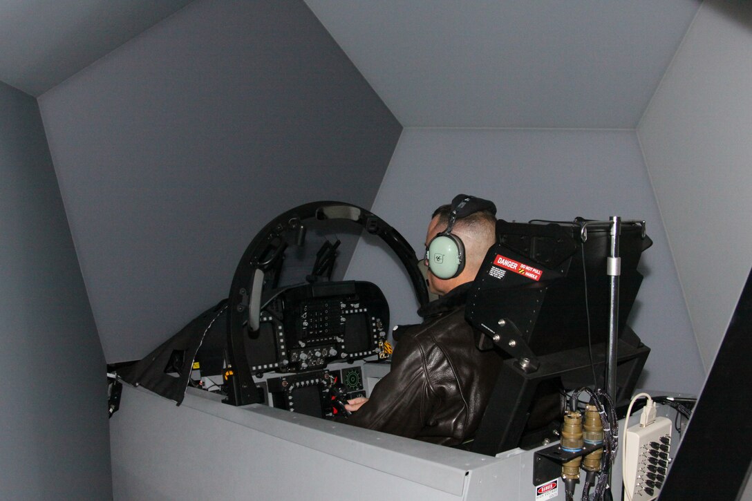 Capt. John Helm, Marine Aviation Training System Site Iwakuni operations officer, gets a feel for the F/A-18D Tactical Operational Flight Trainer 37 in Building 1530 here Nov. 30. THe new trainer, built by L-3 Communications Link Simulation and Training Division, is integrated with Link Simulation and Training's SimuSphere visual system display, allowing for a 360 degree, out-of-window cockpit view and a cockpit sensor image.