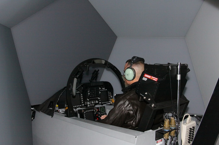 Capt. John Helm, Marine Aviation Training System Site Iwakuni operations officer, gets a feel for the F/A-18D Tactical Operational Flight Trainer 37 in Building 1530 here Nov. 30. THe new trainer, built by L-3 Communications Link Simulation and Training Division, is integrated with Link Simulation and Training's SimuSphere visual system display, allowing for a 360 degree, out-of-window cockpit view and a cockpit sensor image.