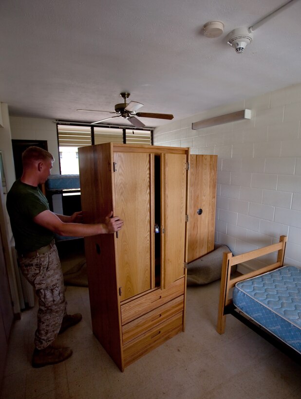 MCB HAWAII - A new smoke alarm sits above a Marine as he rearranges furniture at Barracks 5070 on Marine Corps Base Hawaii, Kaneohe Bay, Oct. 1. Marines Aboard MCB Hawaii were recently moved out of the barracks in mid-July in order to expedite the necessary renovations and is slated to be done by Oct. 18 as Marines begin returning from deployment.(Official U.S. Marine Corps photo by Cpl. Achilles Tsantarliotis)(Released)