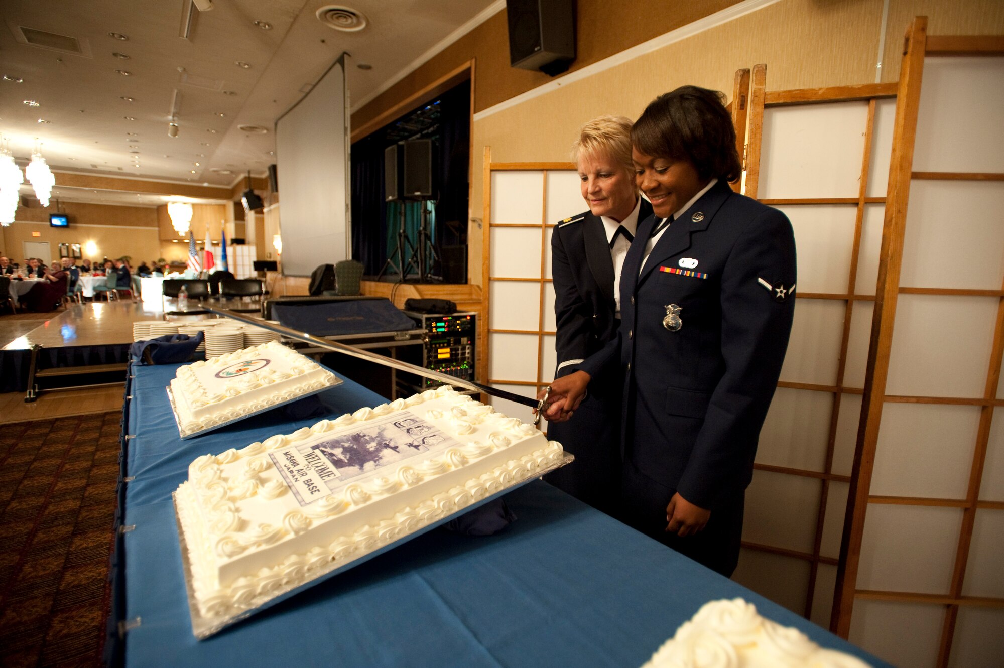 MISAWA AIR BASE, Japan -- Maj. Kathleen Martin, 35th Medical Group flight commander for labor and delivery, and Airman 1st Class Rodalyn Wofford, 35th Security Forces basic force protector, cut the cake at the 62nd Air Force Ball in the enlisted club ballroom. This time-honored tradition pairs the most senior and junior in age military member to cut the cake during the ceremony. (U.S. Air Force photo/Staff Sgt. Samuel Morse)