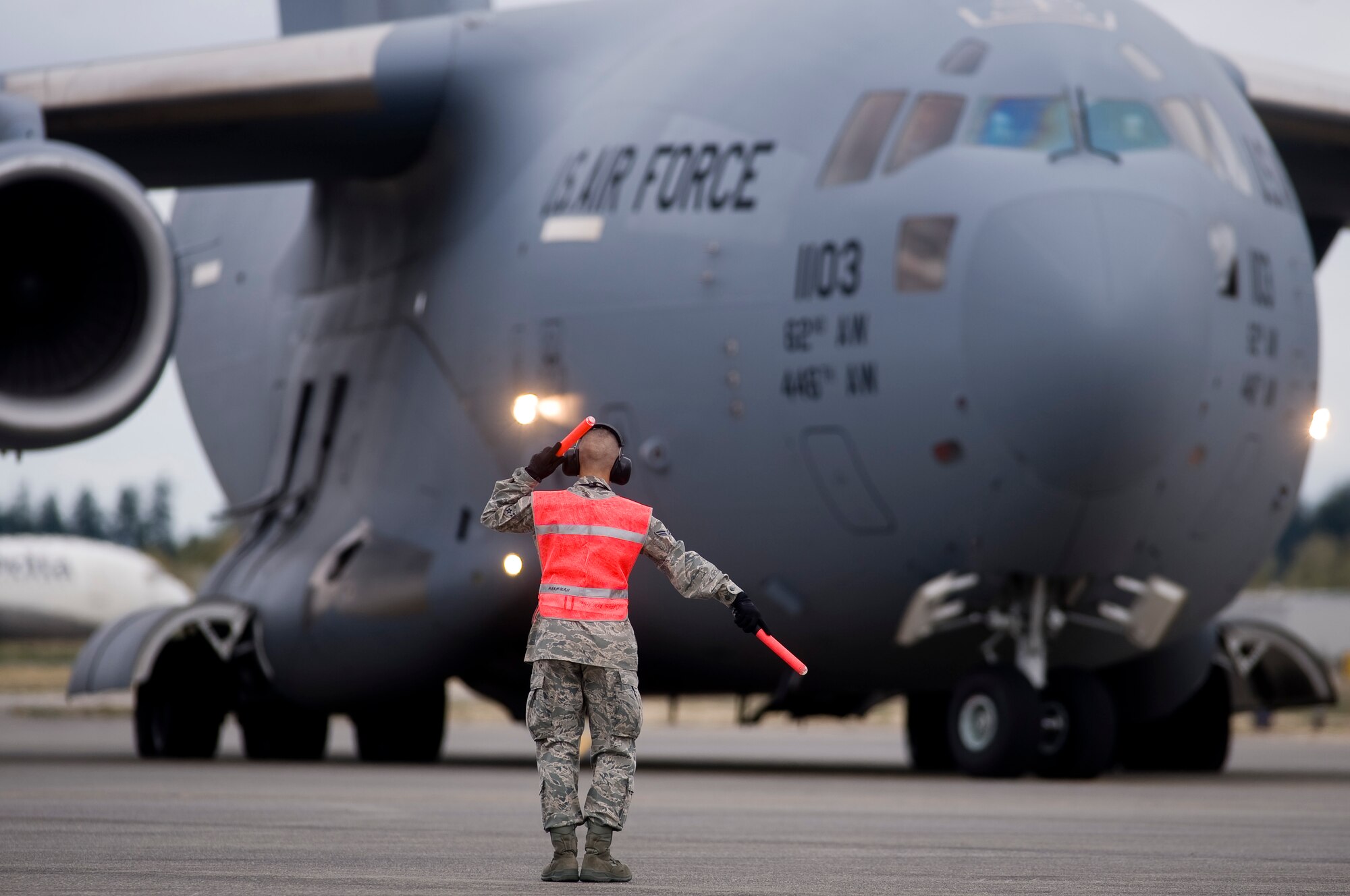 MCCHORD AIR FORCE BASE, Wash. – Airman Basic Ruben Rojas, 62nd Aircraft Maintenance Squadron, marshals a C-17 Globemaster III on the flightline Oct 1. In the wake of a 7.6 magnitude undersea earthquake that caused a devastating tsunami to strike American Samoa, McChord Airmen, on-alert to support any tasking associated with a mounting relief effort, deployed a U.S.-based FEMA team to the region at 2 p.m. (U.S. Air Force photo/Abner Guzman)