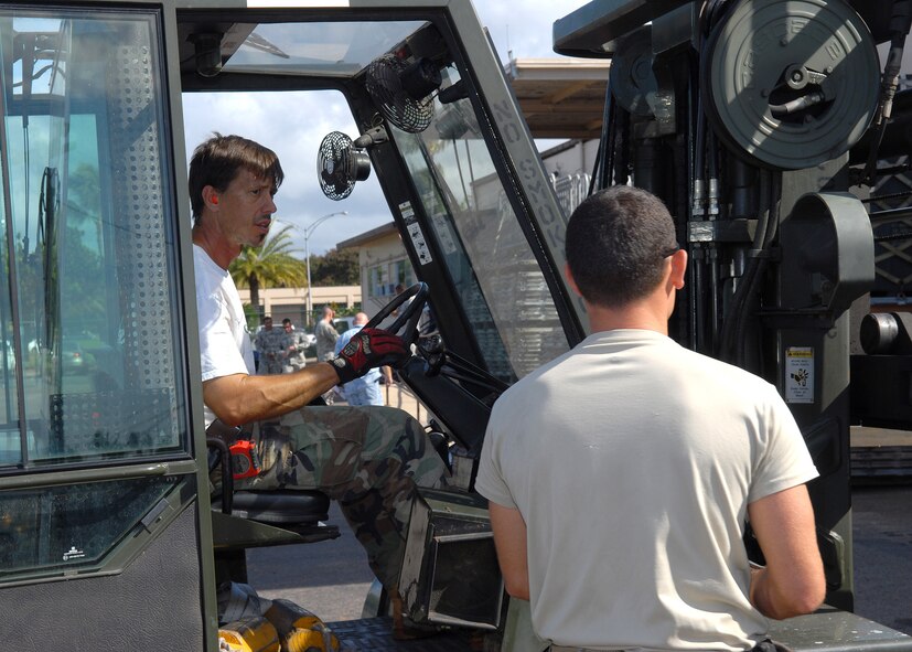 Matt Tramuto and Staff Sgt. Nathan Angel load pallet of supplies as part of a humanitarian mission to American Samoa Sept. 30 at Hickam Air Force Base, Hawaii. Two C-17 Globemaster IIIs carried the supplies and approximately 100 military personnel to the island nation, which was devastated by an earthquake and Tsunami Sept. 29. Mr. Tramuto is with the 15th Maintenance Group and Sergeant Angel is with the 15th Logistics Readiness Squadron.  (U.S. Air Force photo/Tech. Sgt. Jerome S. Tayborn)