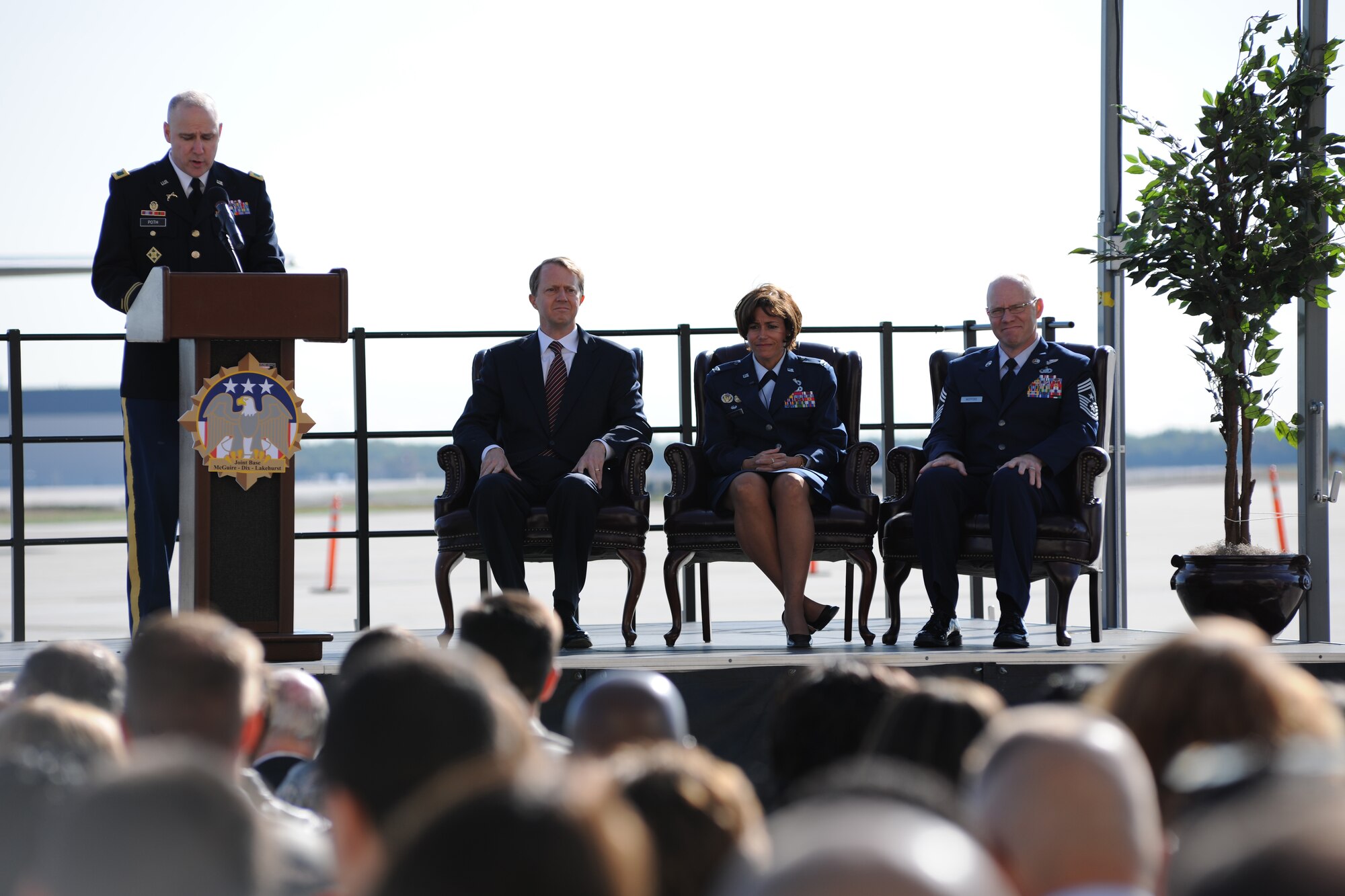 Master of Ceremonies, Col. Joe Poth, speaks to the citizens of Joint Base McGuire-Dix-Lakehurst at a commander’s call on Oct.1, as Congressman John Adler, Col. Gina Grosso, and Chief  Master Sgt. Warren Wofford  look on.The commander’s call marks the inauguration of America’s first tri-service base. (U.S. Air Force photo/Staff Sgt. Nathaniel Bevier)