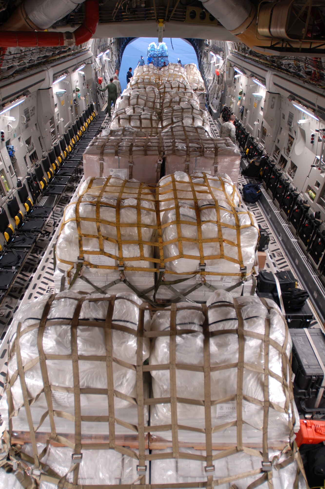 HICKAM AIR FORCE BASE, Hawaii -- Humanitarian aid supplies from the Federal Emergency Management Agency is loaded by Hawaii Air National Guard, Hawaii National Guard and Hickam Active Duty Airmen into a C-17 Globemaster III bound for American Samoa to assist in the relief efforts underway Sept 30. The efforts are in the wake of tsunamis triggered by an undersea earthquake Sept. 29 that has left more than 140 people dead in the South Pacific region. More than 90 Airmen and Soldiers deployed from Hawaii for the humanitarian mission. (U.S. Air Force photo/Staff Sgt. Mike Meares)