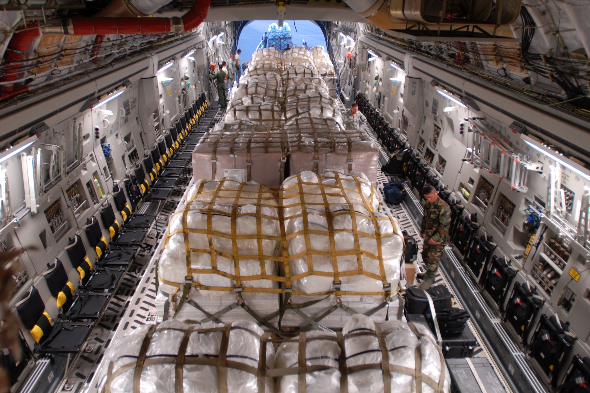 HICKAM AIR FORCE BASE, Hawaii -- Humanitarian aid supplies from the Federal Emergency Management Agency is loaded by Hawaii Air National Guard, Hawaii National Guard and Hickam Active Duty Airmen into a C-17 Globemaster III bound for American Samoa to assist in the relief efforts underway Sept 30. The efforts are in the wake of tsunamis triggered by an undersea earthquake Sept. 29 that has left more than 140 people dead in the South Pacific region. More than 90 Airmen and Soldiers deployed from Hawaii for the humanitarian mission. (U.S. Air Force photo/Staff Sgt. Mike Meares)